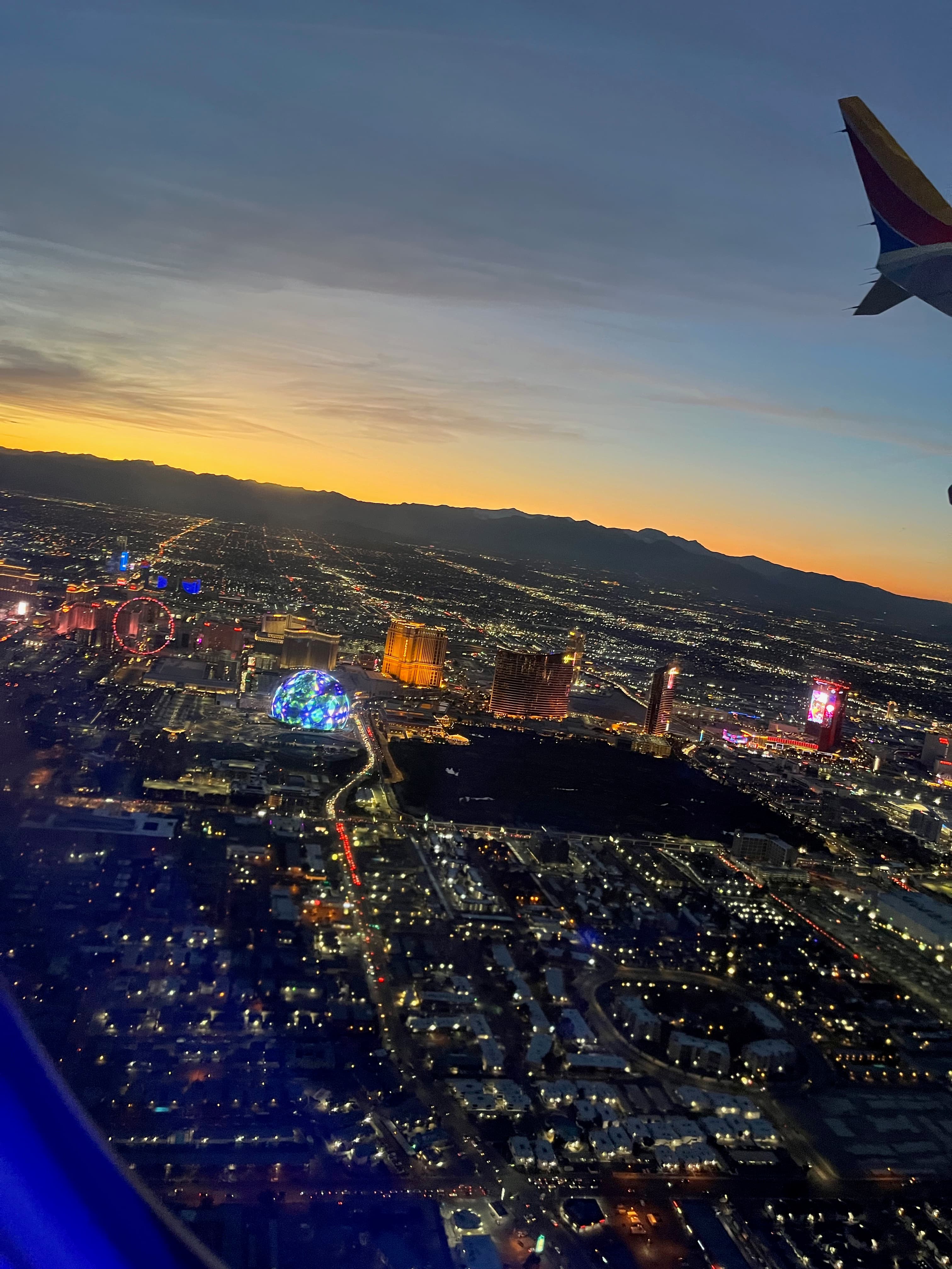 View from a plane window of the Las Vegas strip lit up at sunset
