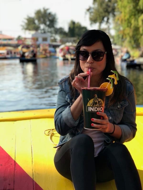 Picture of Michelle wearing sunglasses and drinking from a large cup on a yellow and red boat