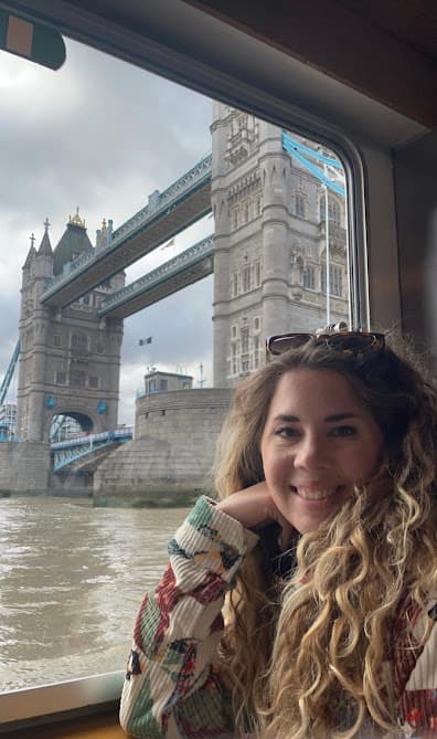 Advisor posing for an image with a bridge and a waterway in the distance.