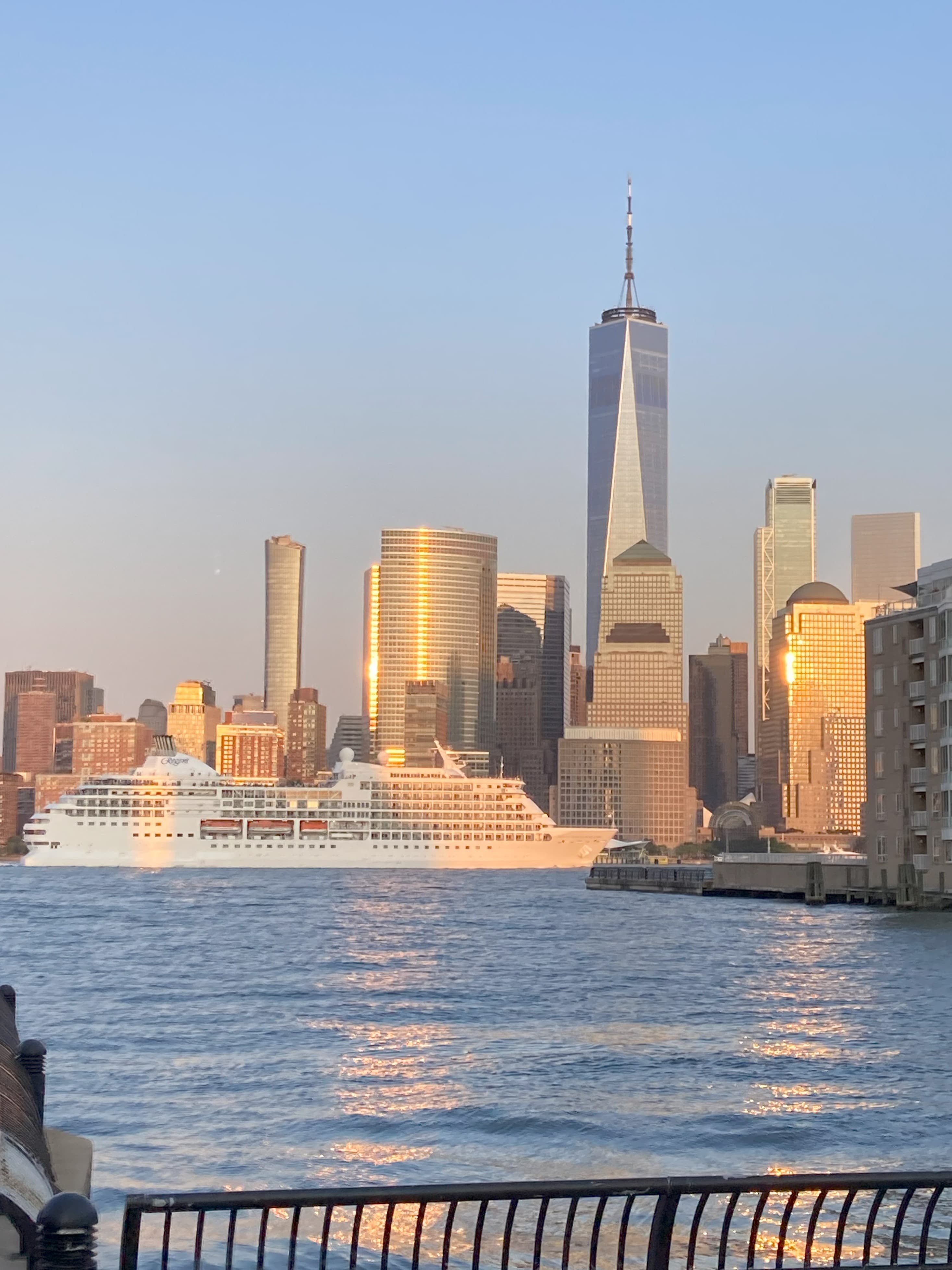 A photo of the New York skyline from the river during golden hour.