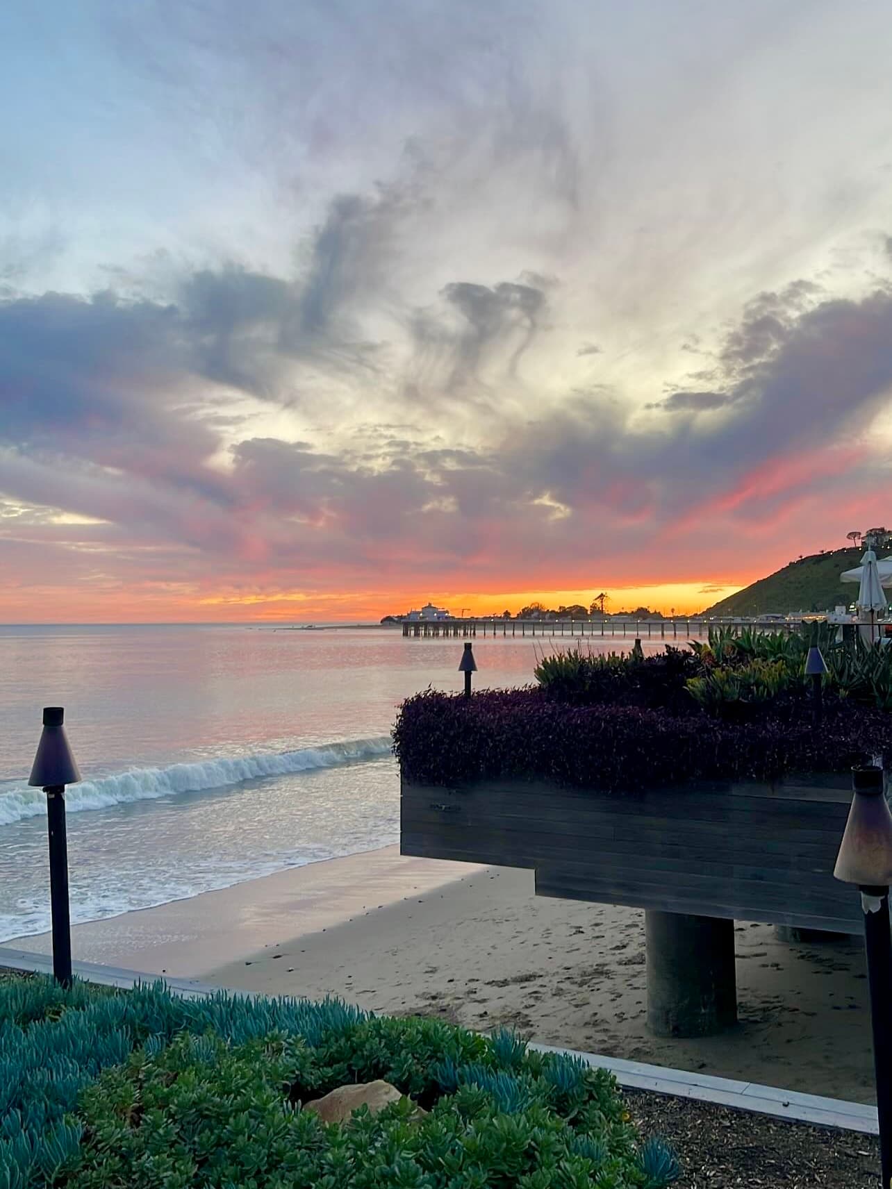 Beautiful view of a sunset overlooking the ocean and a nearby pier