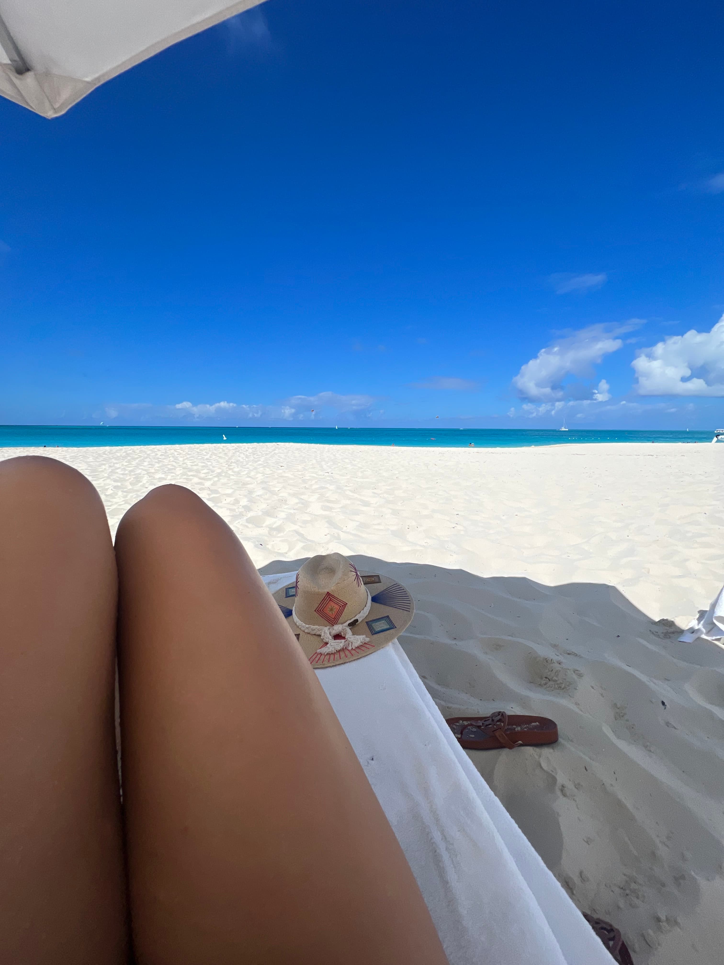 Advisor lounging on the beach with the ocean in the distance.