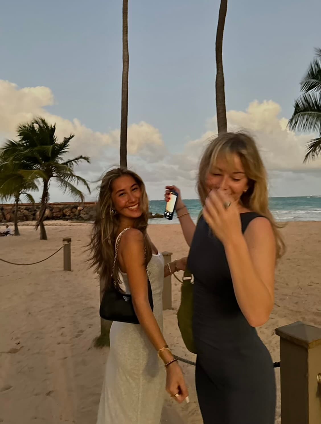 Two girls having fun on the beach at dusk.