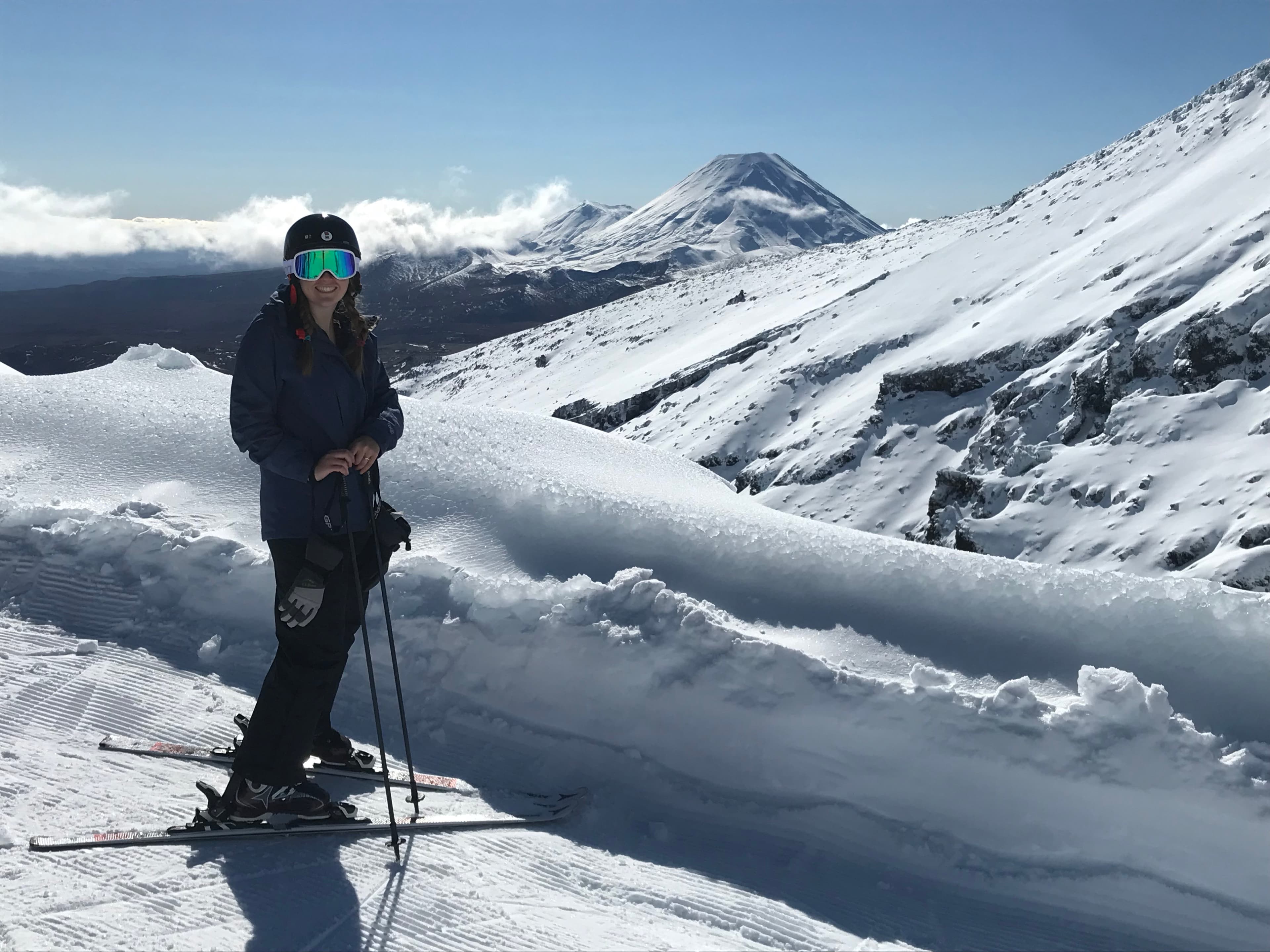 Advisor posing on a sunny day in a snow covered region with skis on.