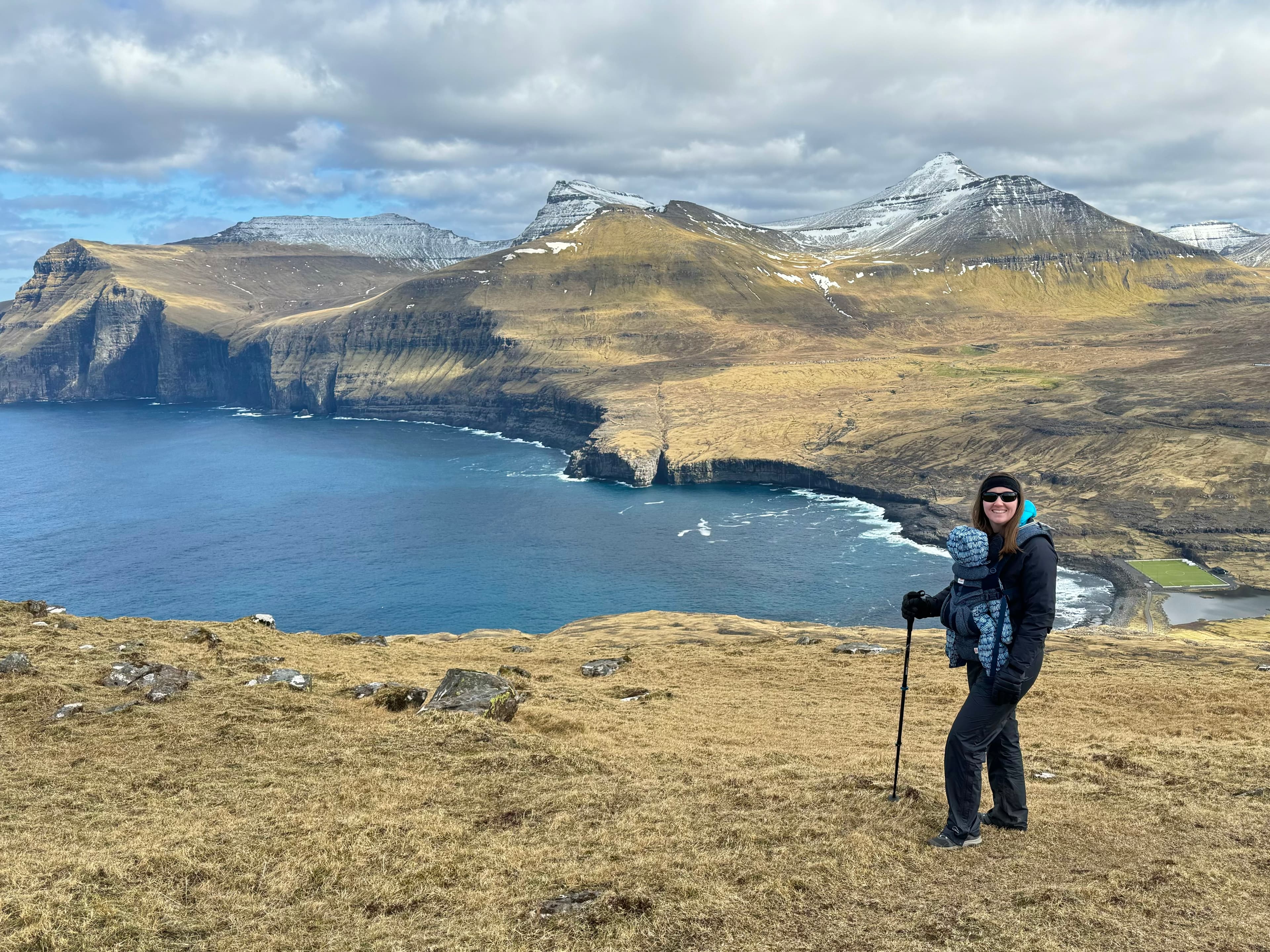 Advisor hiking in a hill region with a lake in the distance on a sunny day.