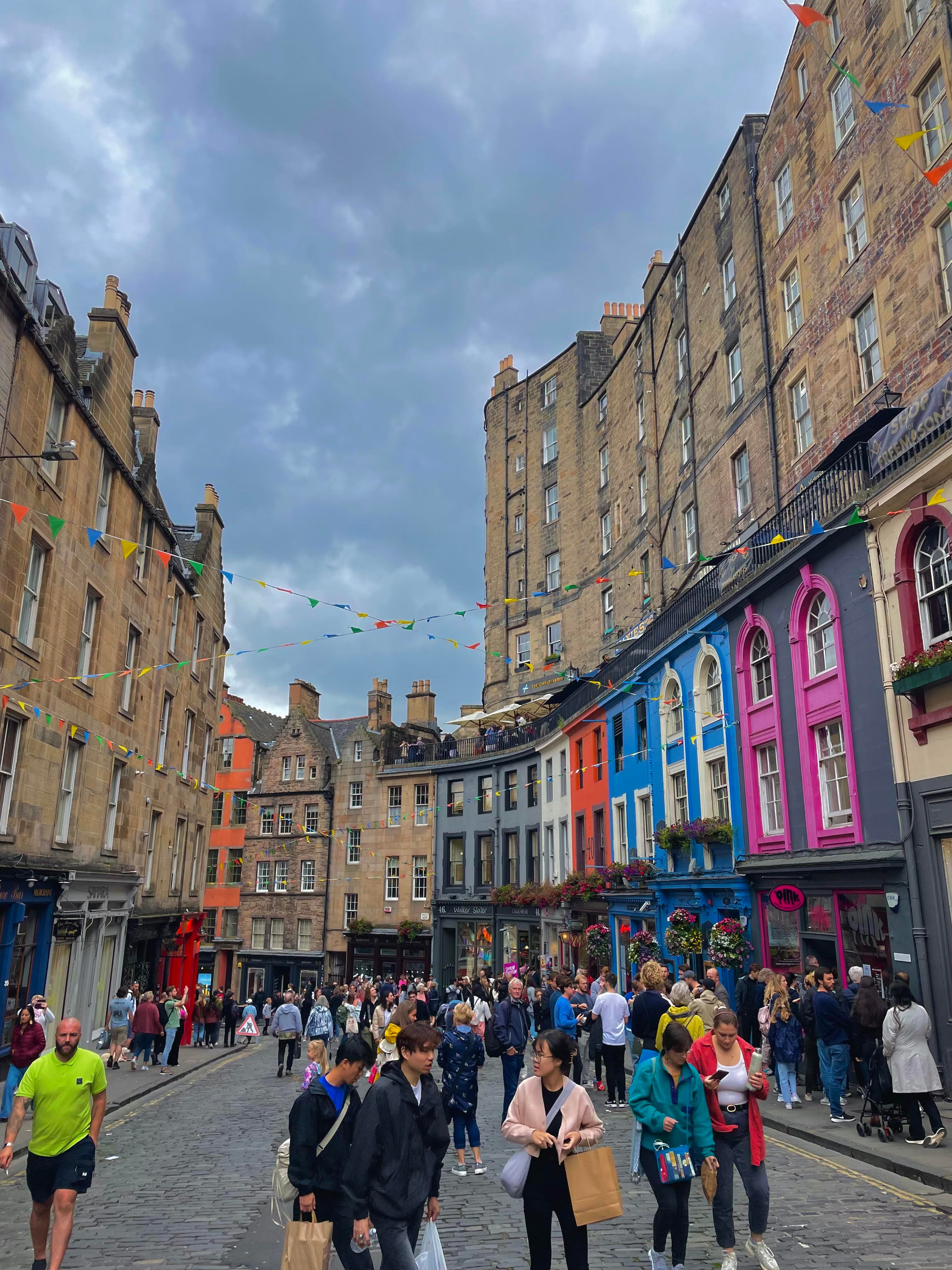 Pretty view of a colorful, building-lined street in Edinburgh on a cloudy day