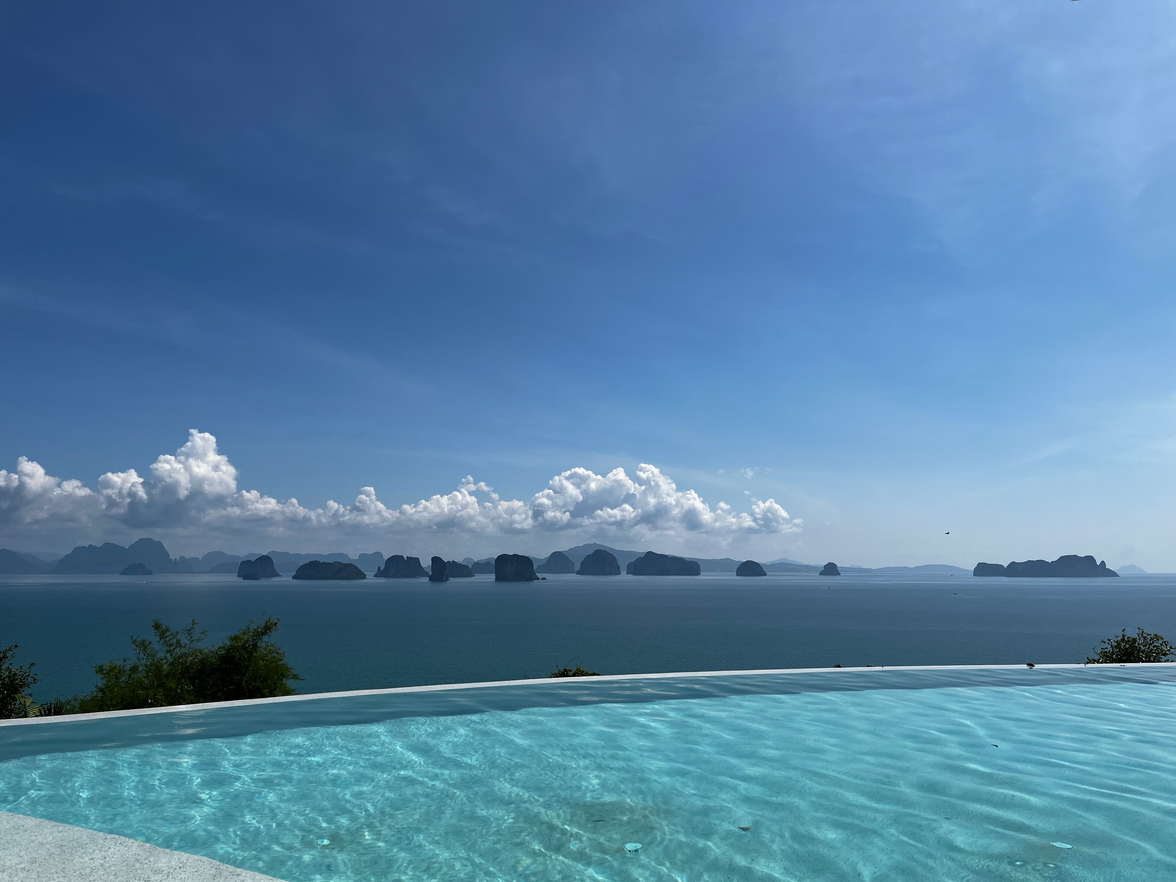 Infinity pool with a beautiful view of the ocean and distant islands on a sunny day