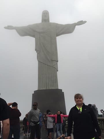 View of Rio’s Christ the Redeemer statue in hazy weather with tourists at the base