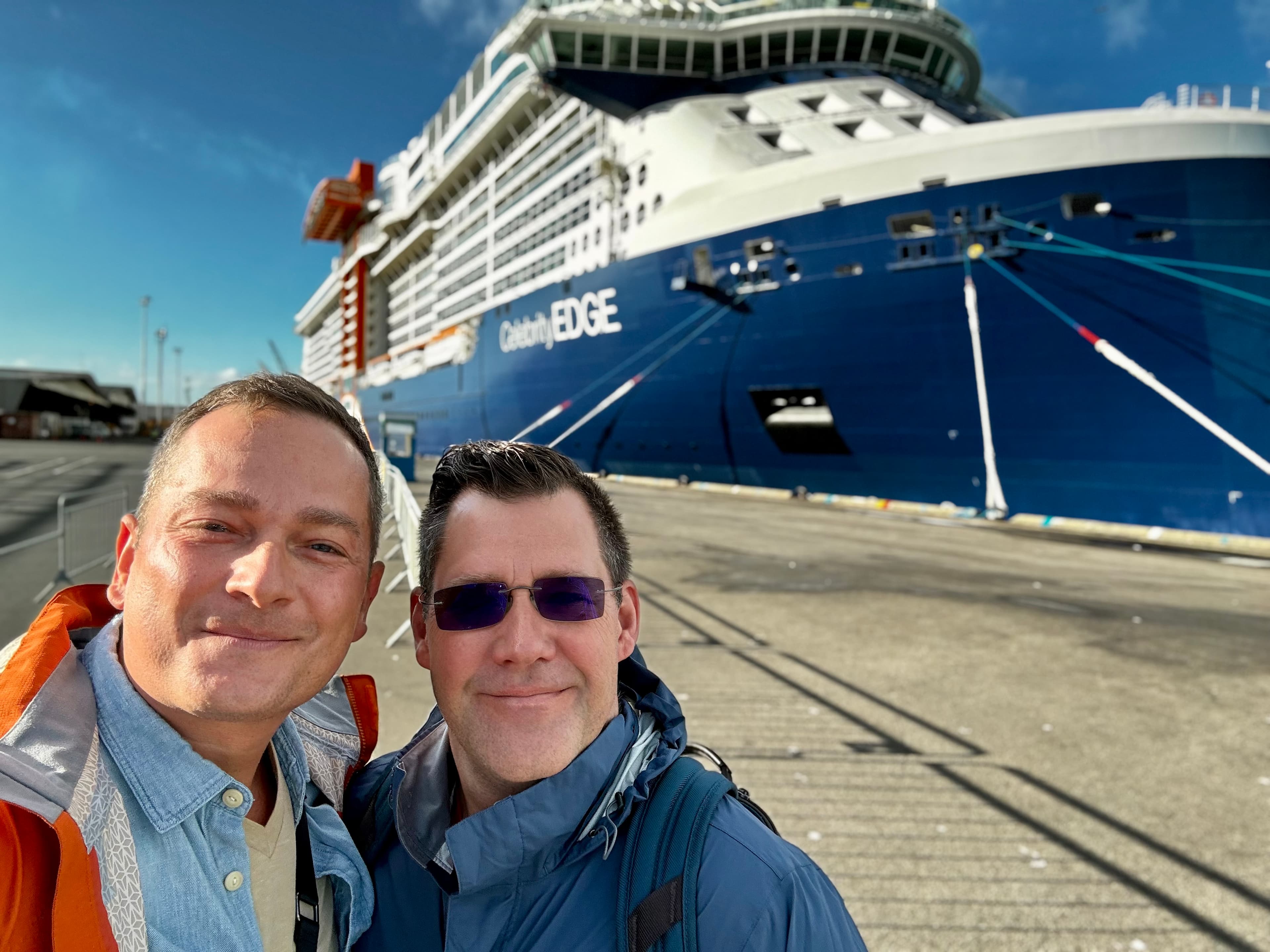 Advisor and his partner taking a selfie in front of a cruise ship during the day