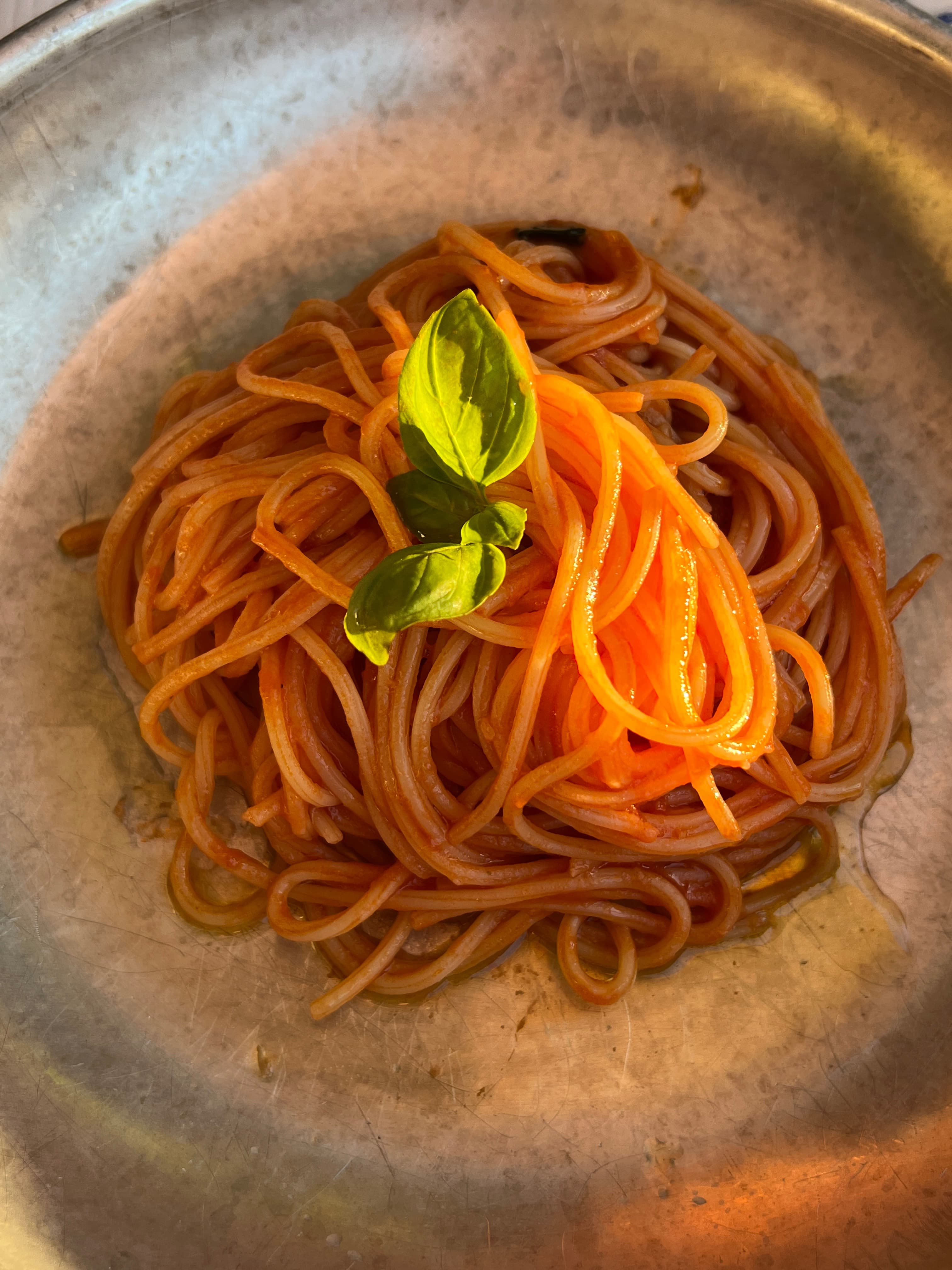 Pretty image of pasta with basil on a round plate
