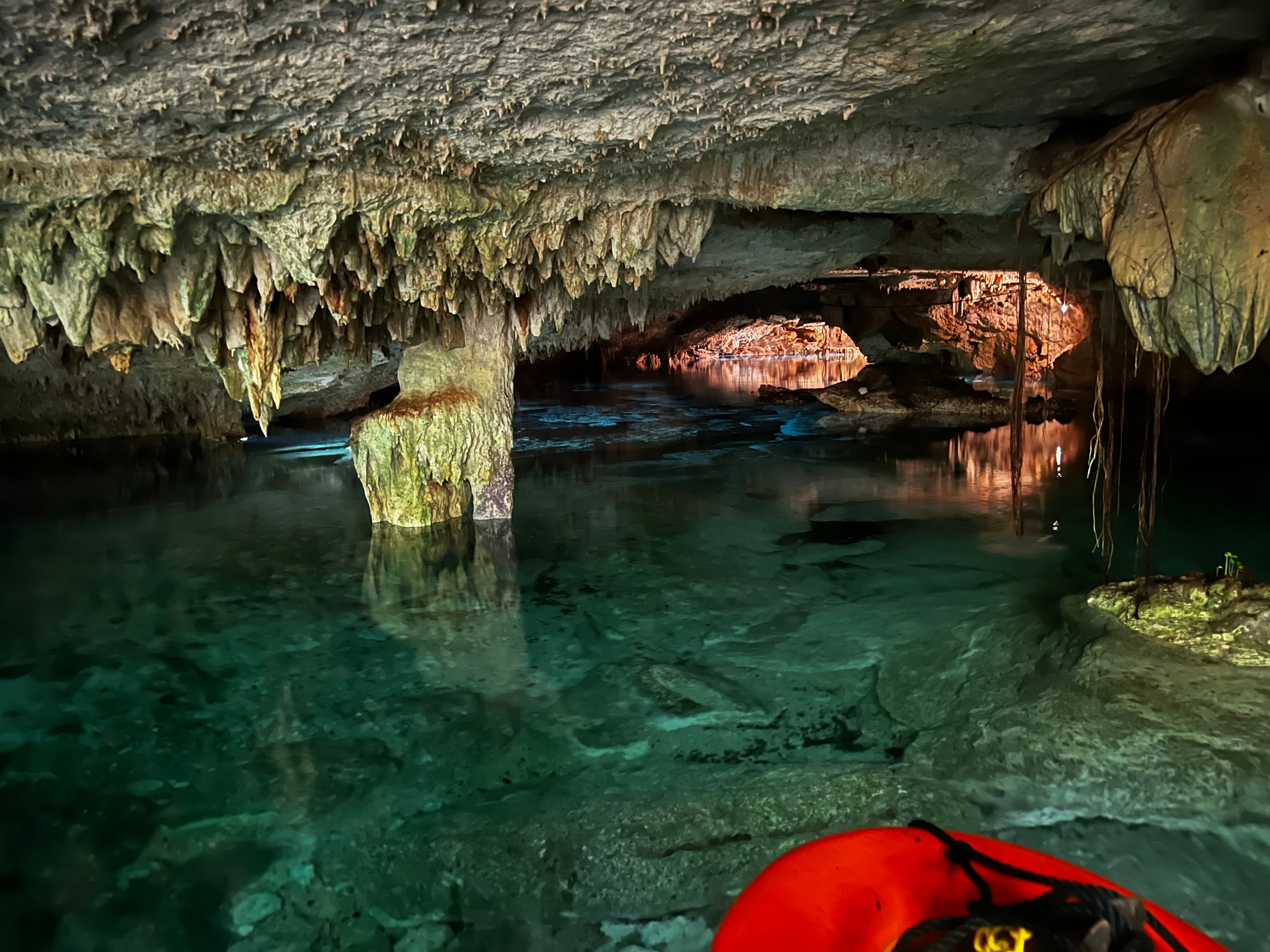 A cave with stalagmites and a fresh body of water.