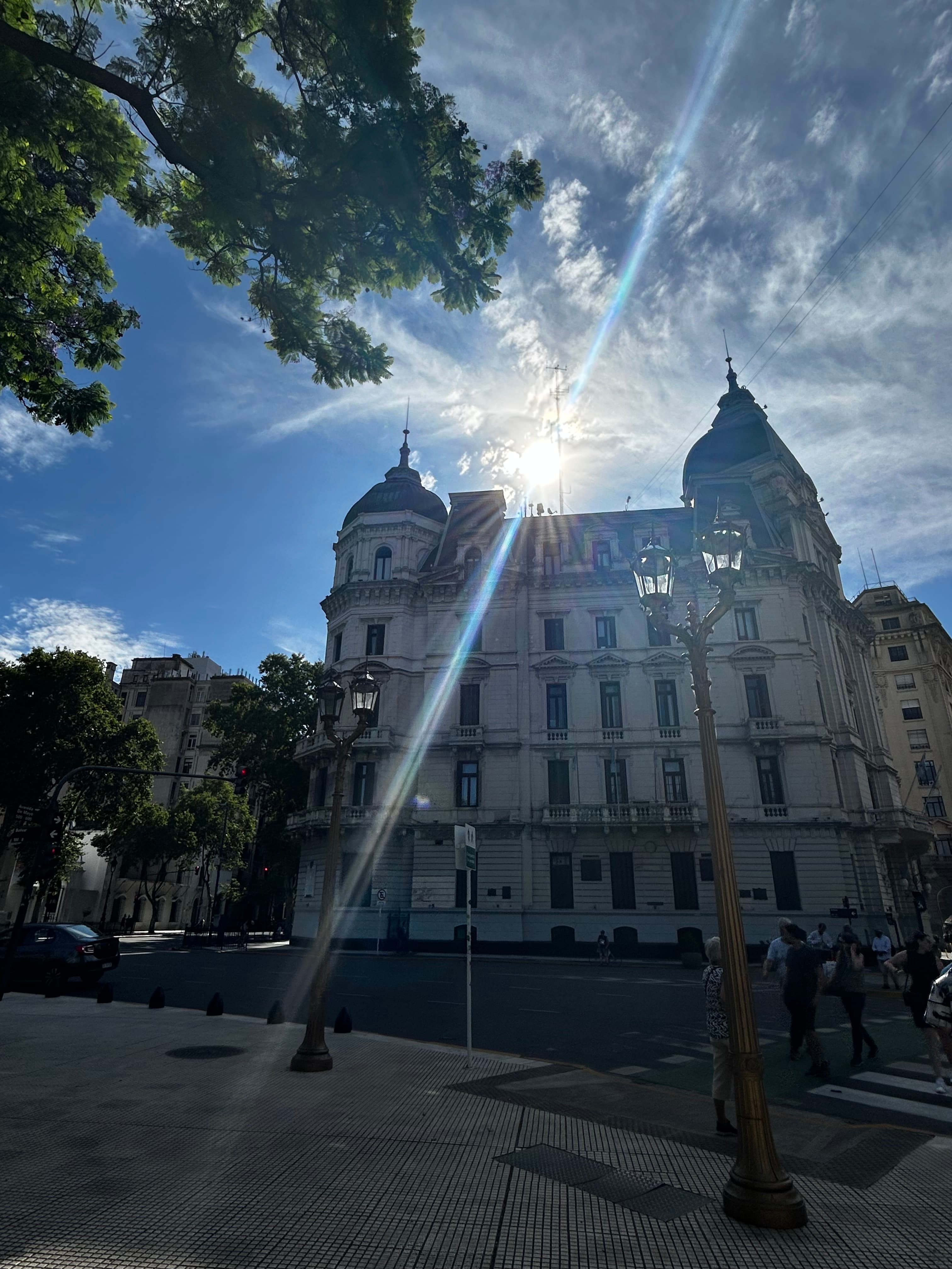 Pretty view from the road of an old building with many windows with the sun shining over the top