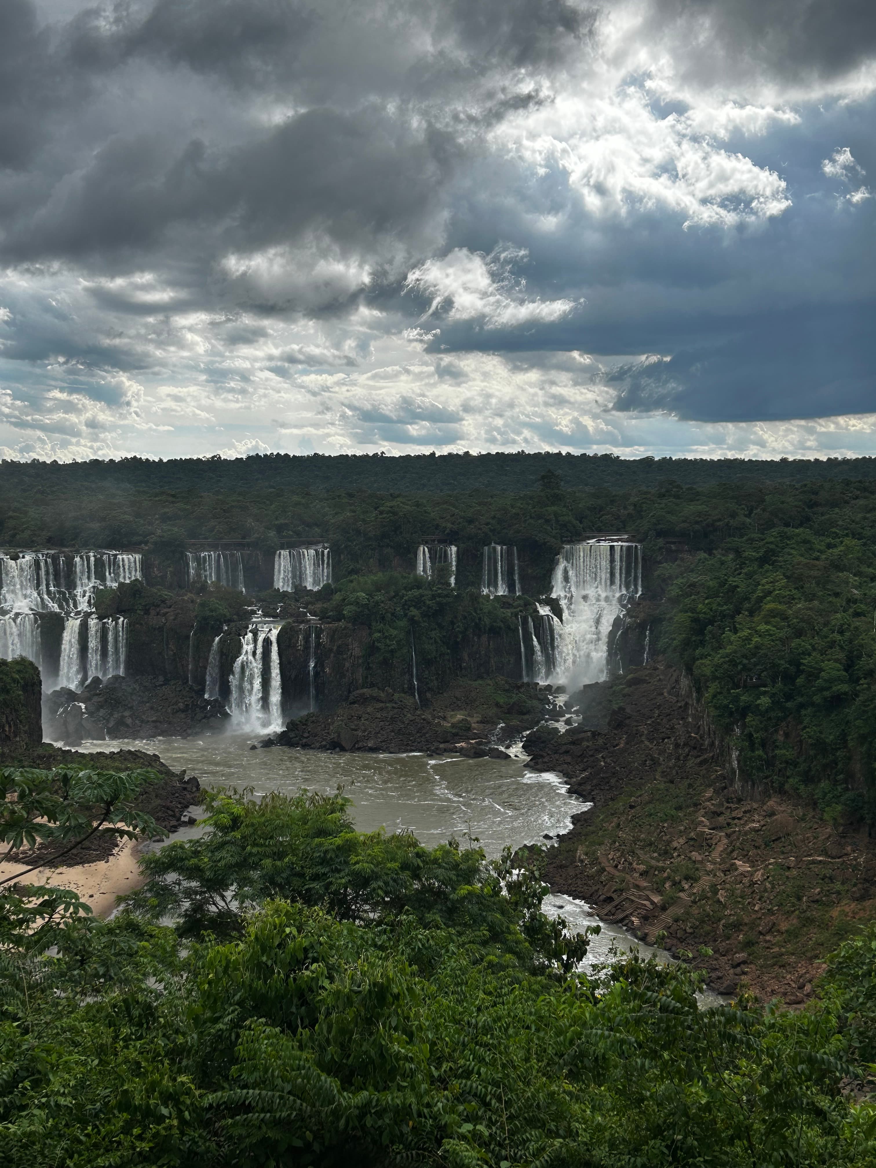 Aerial view of a large waterfall with several different sections surrounded by lush green forest