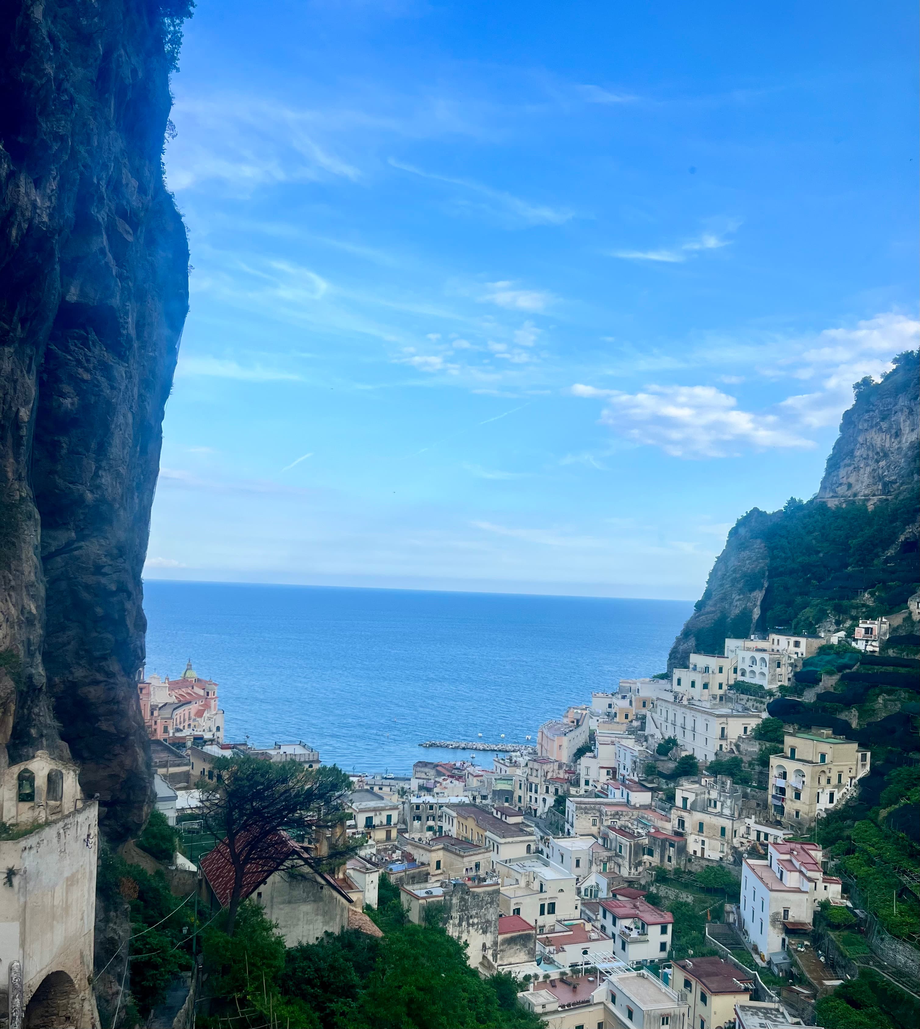 An aerial view of a coastal town on a mountainside during the day.