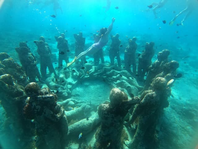 View of an underwater sculpture representing a group of people sitting in a circle