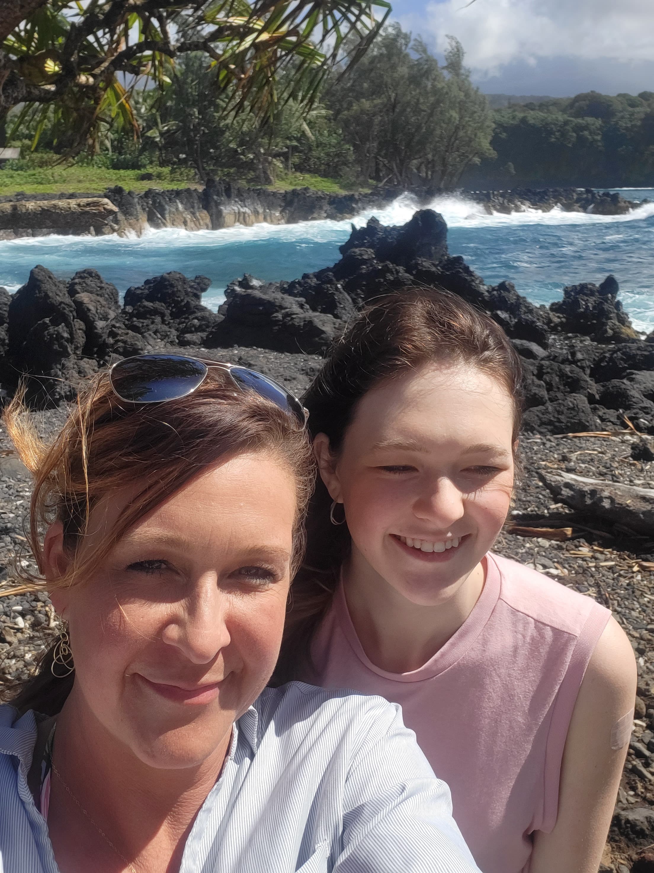 Two people standing by the rocks next to water.
