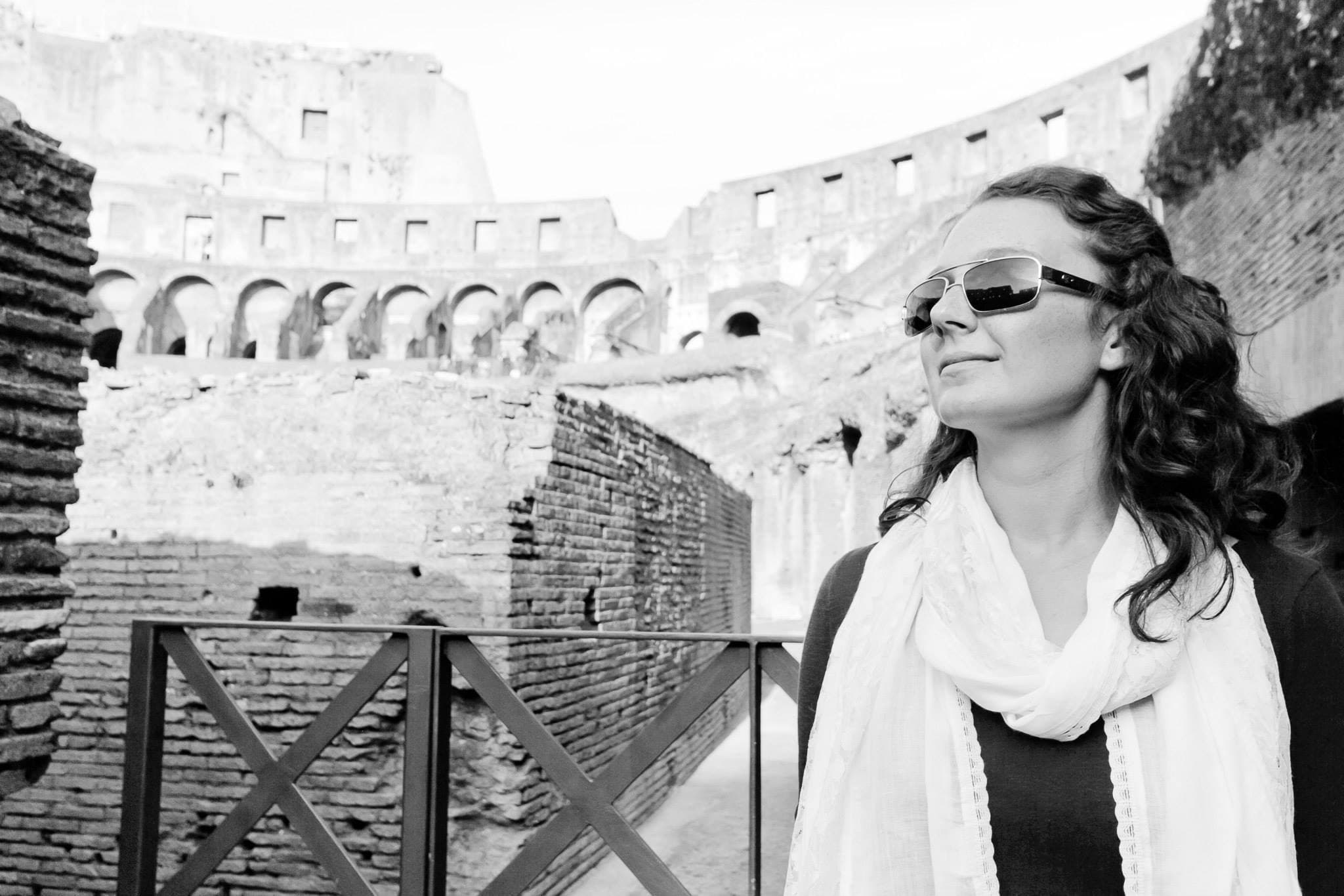Black and white photo of Kayla wearing sunglasses inside the Colosseum