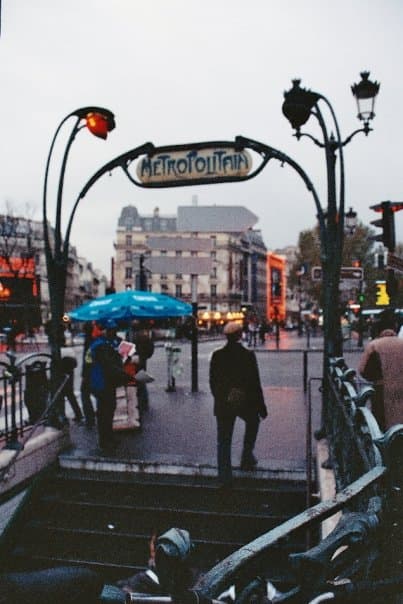 View of a staircase on the street leading down to the Paris metro metro system on a rainy day