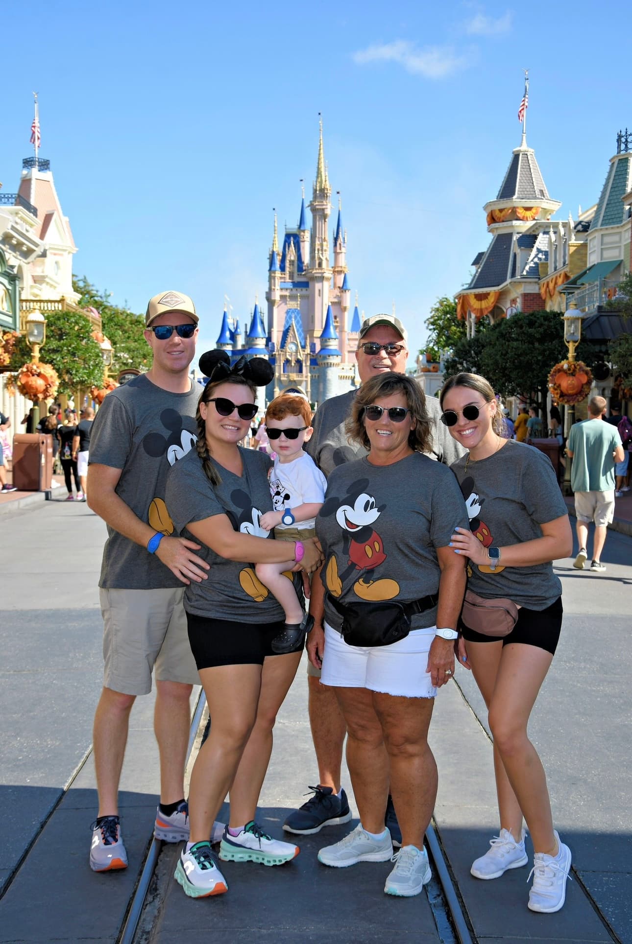 Group of friends posing outdoors with mickey mouse shirts.