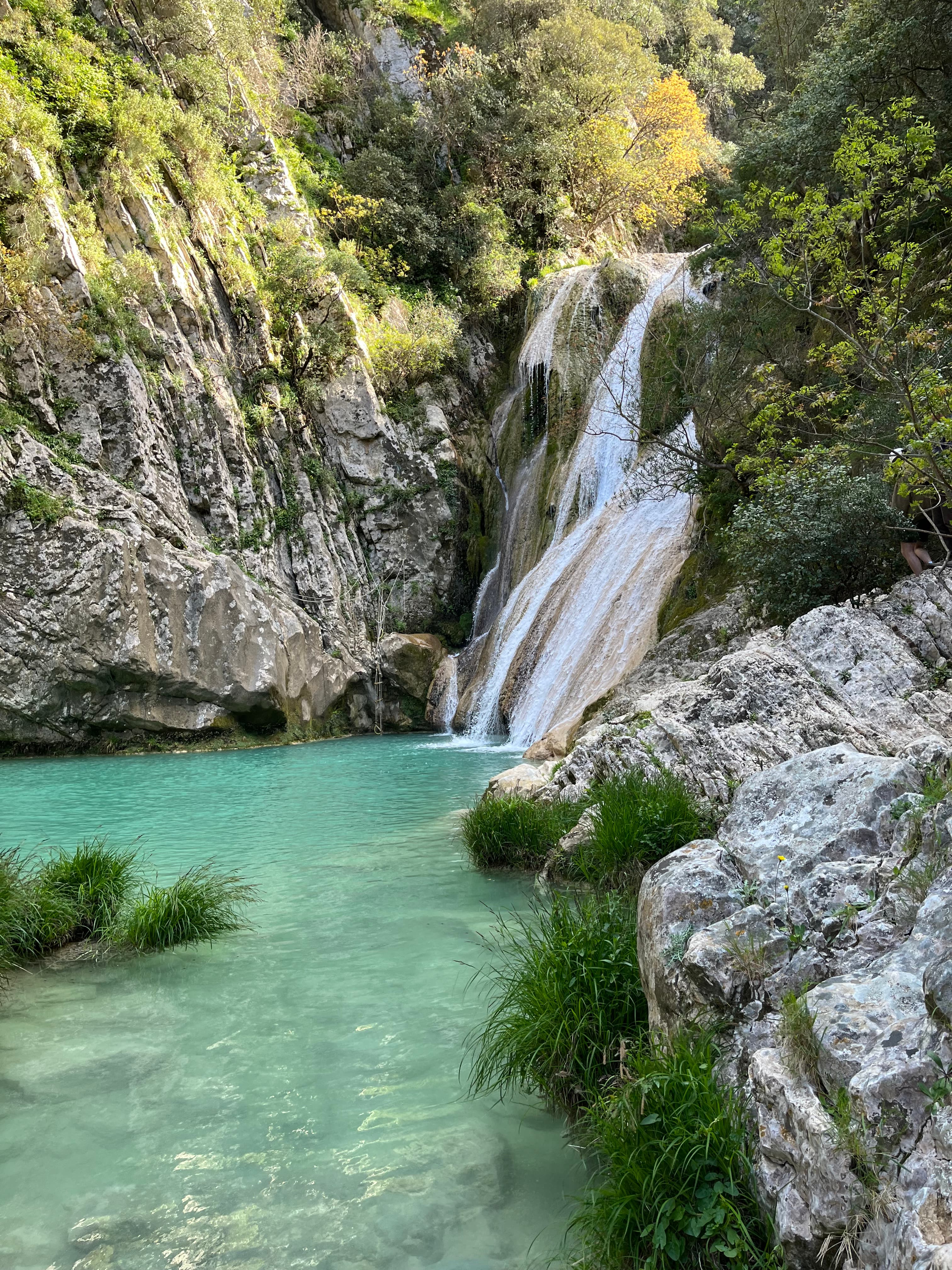 A waterfall surrounded by the mountains.