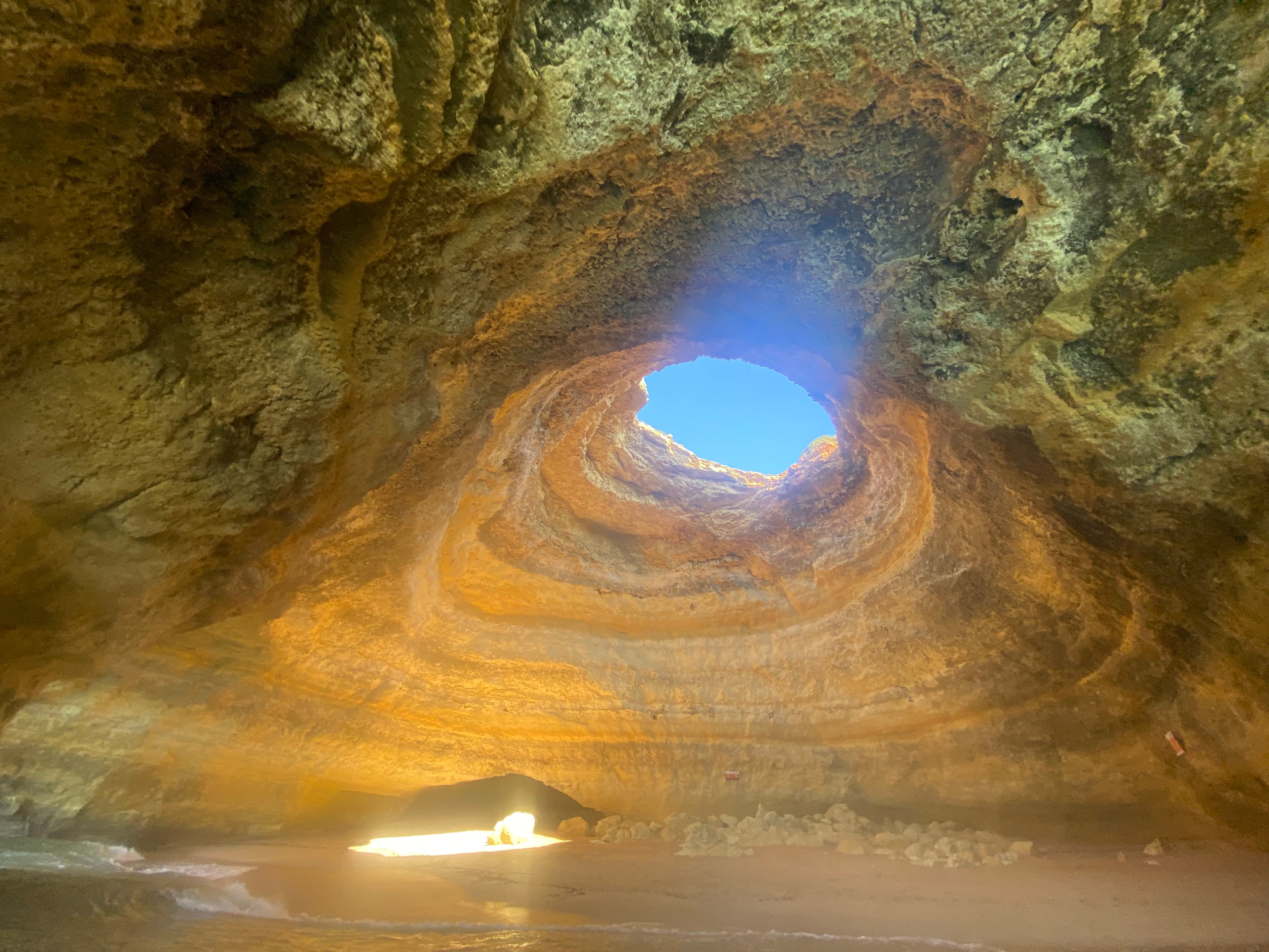 View of a hole in the top of a large cave as seen from below