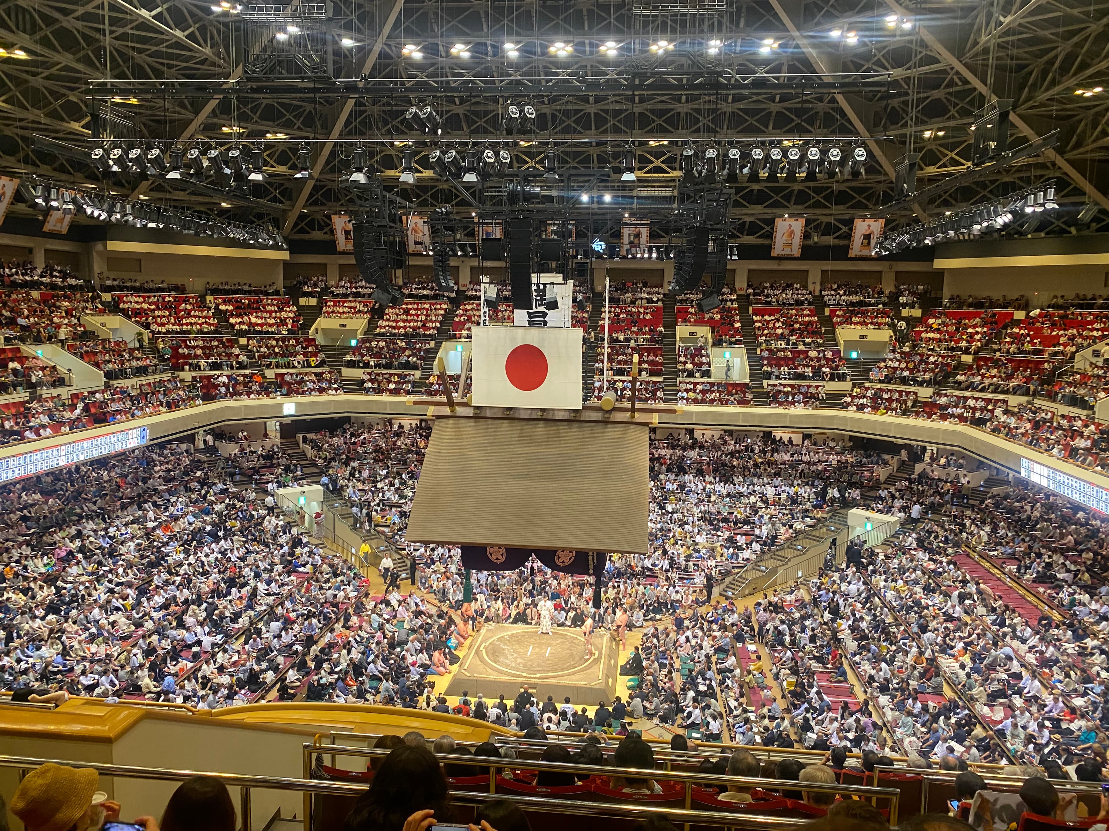 View of a large stadium filled with people under a Japanese flag