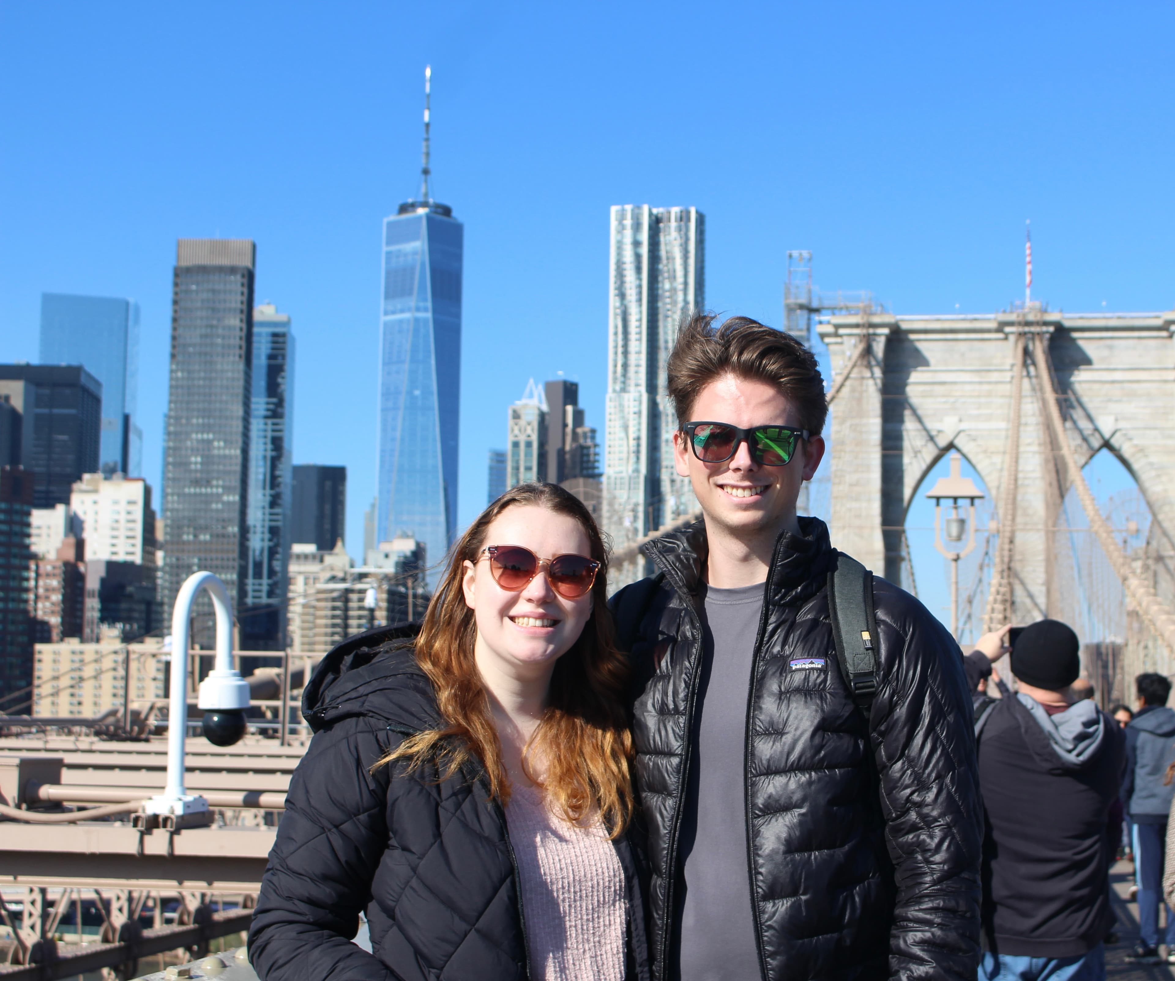 Advisor and partner in black jackets posing in front of some buildings during the daytime.