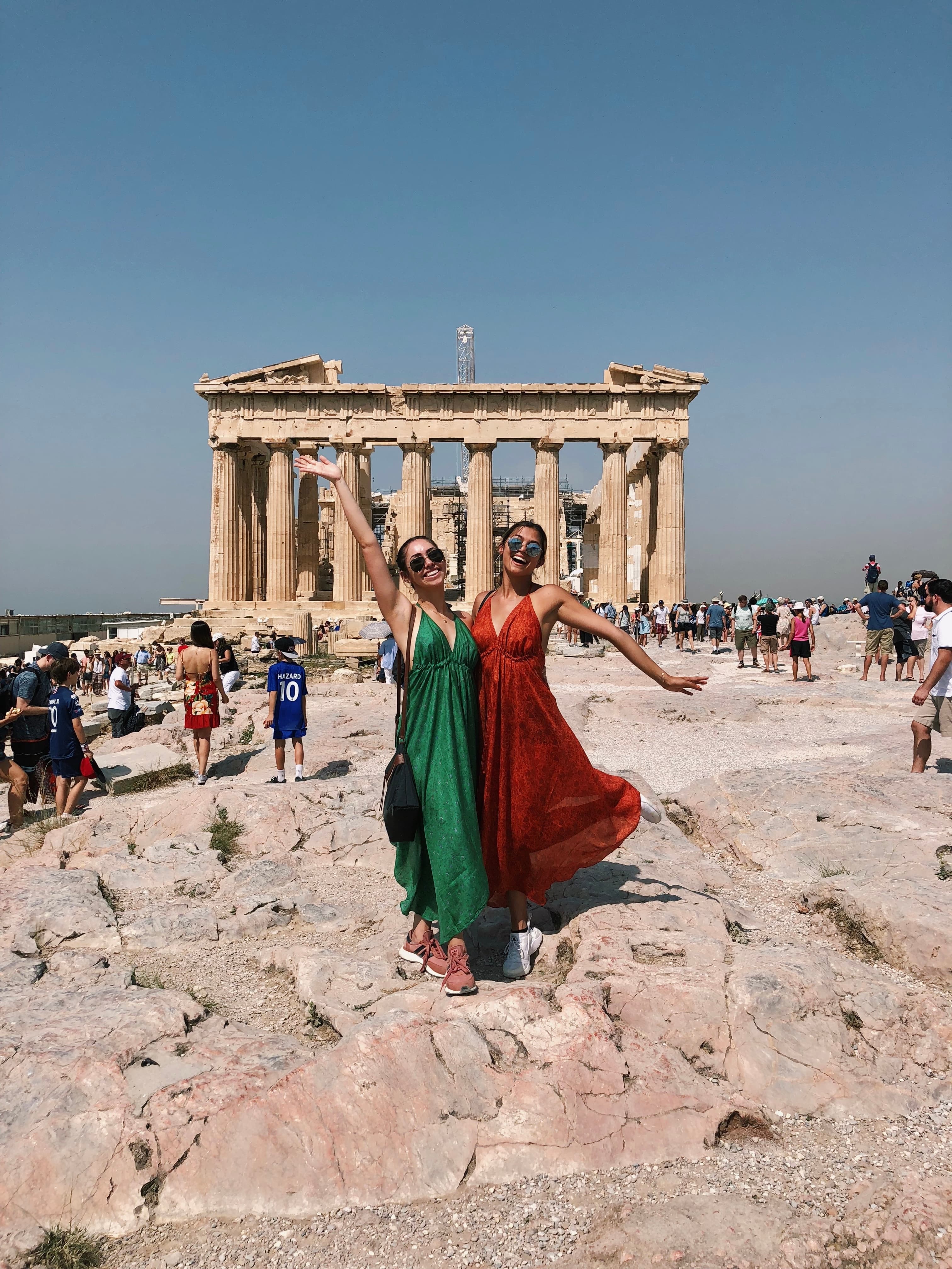 Advisor posing in front historical landmark with milling crowds in the background on a sunny day.