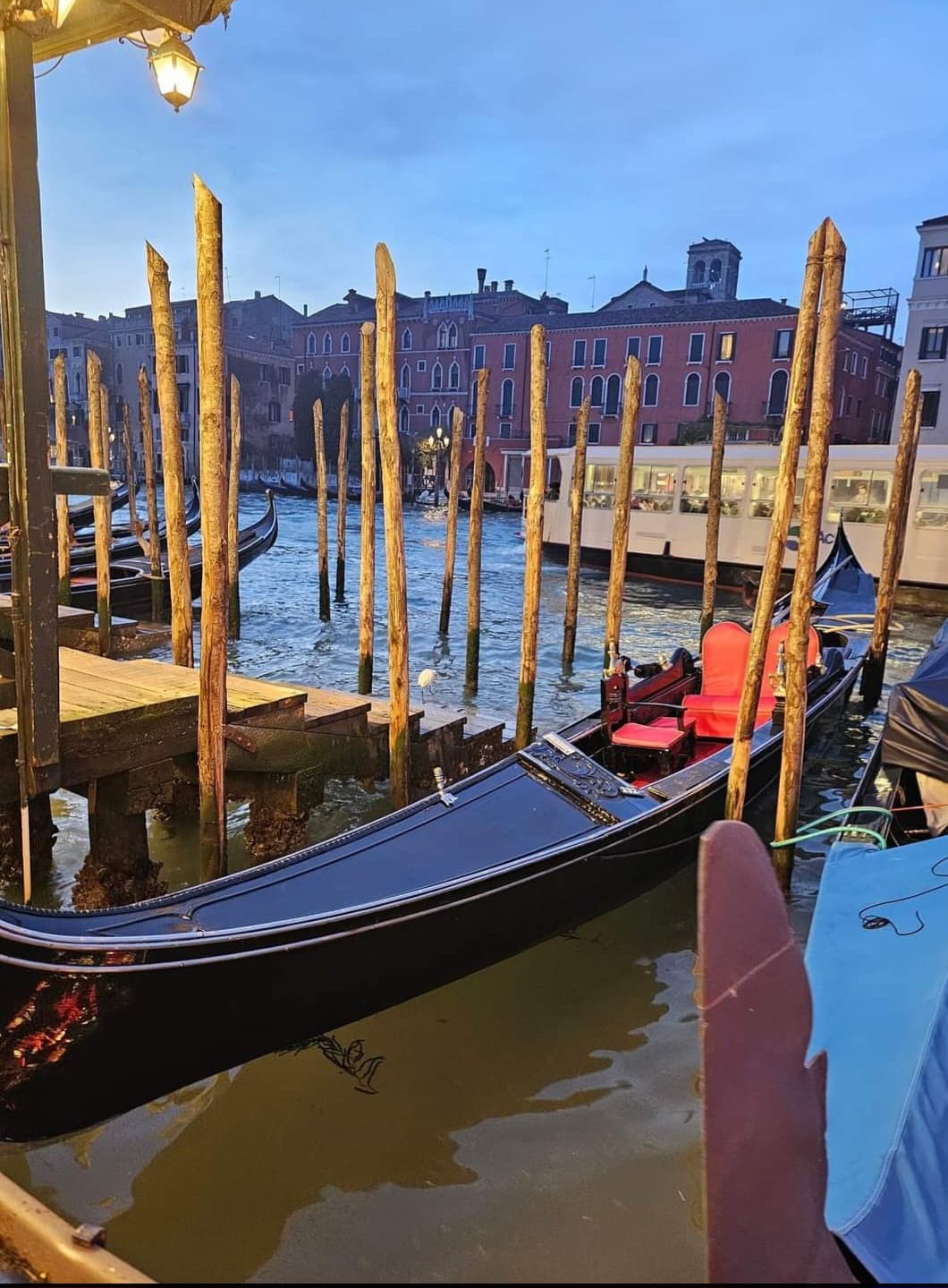 View of a gondola docked on a canal in Venice, Italy at sunset