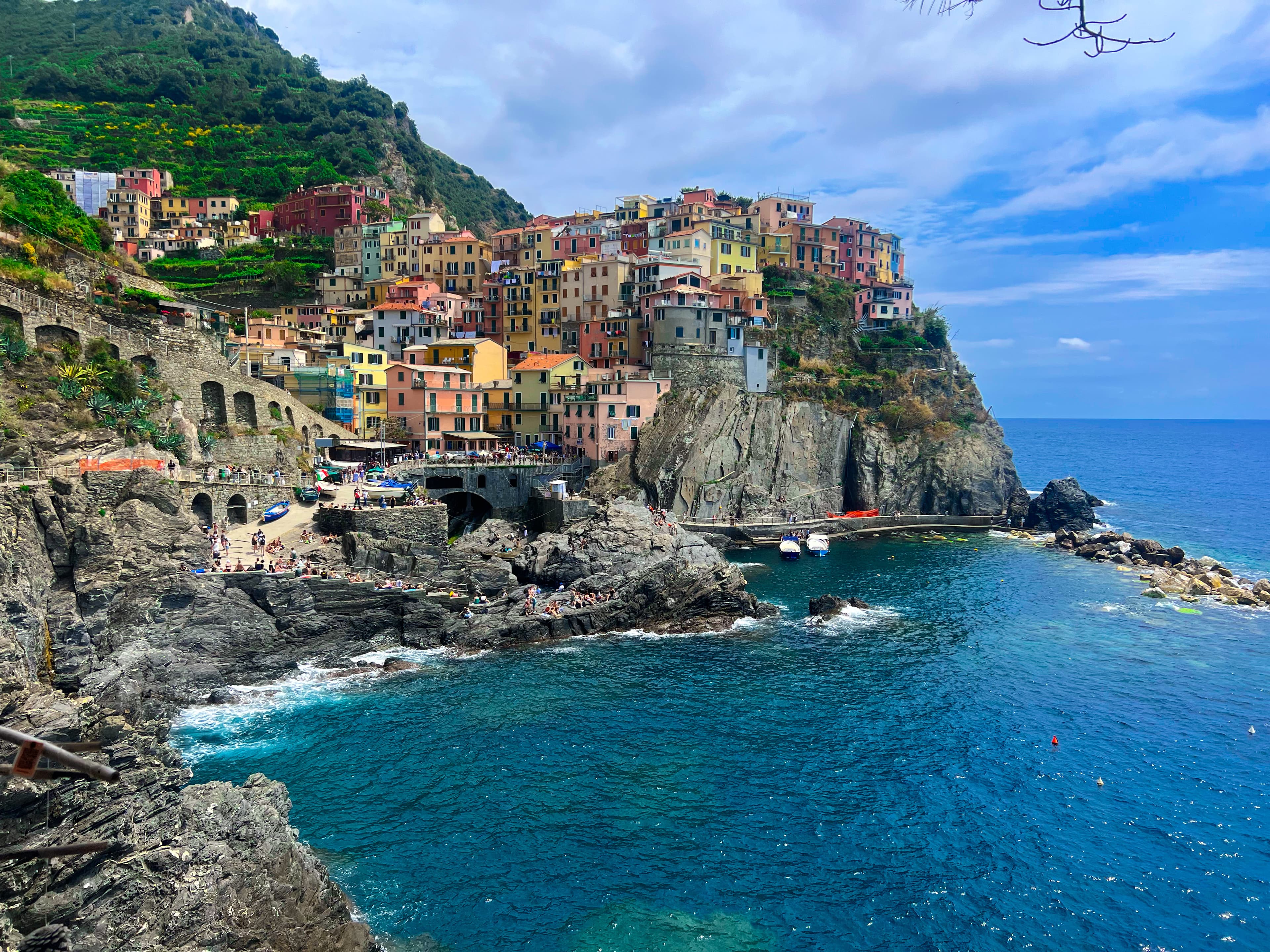 Vibrant houses perched on the Italian coast cliff, overlooking the sparkling blue sea.