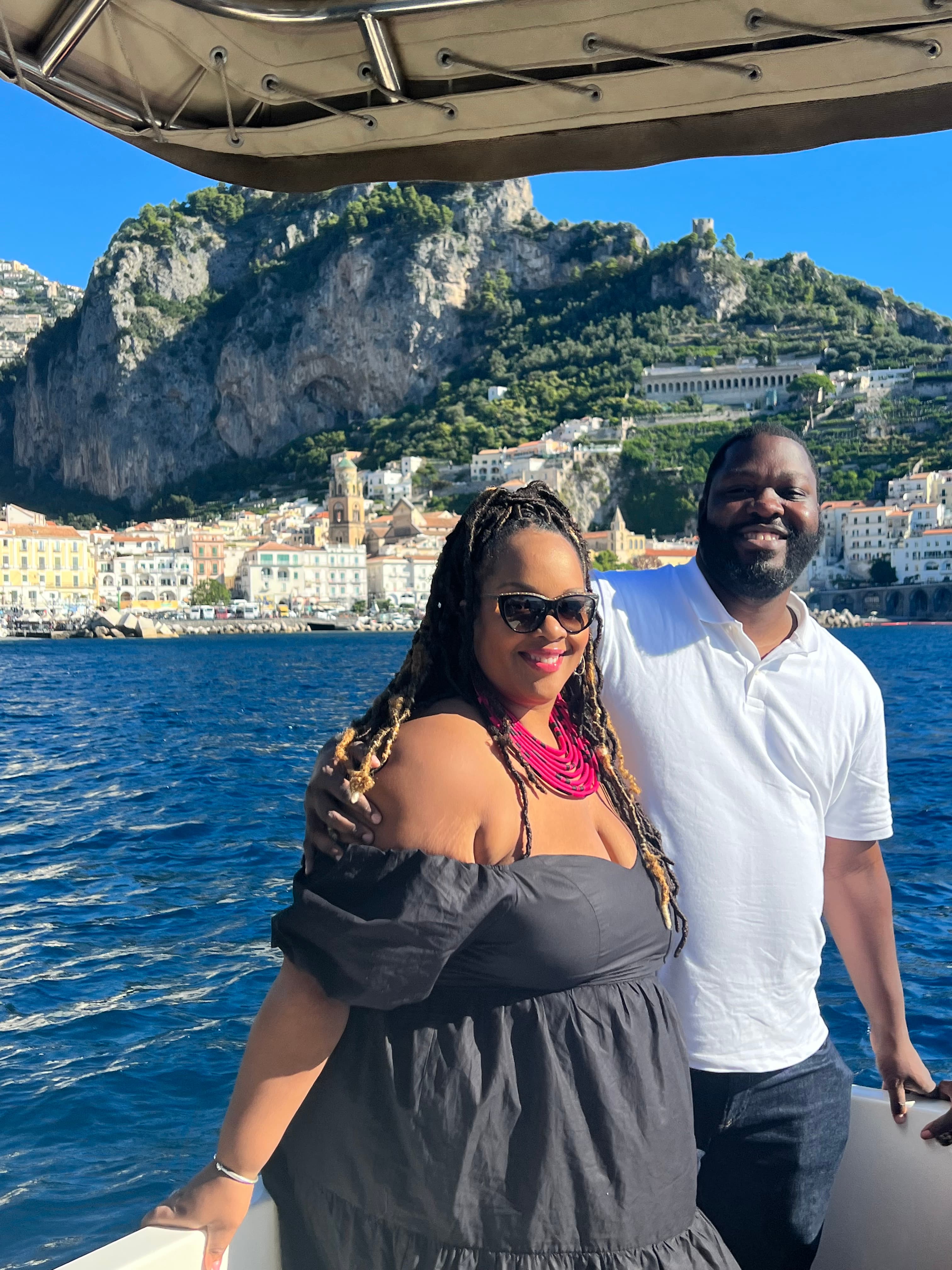 A couple posing for an photo on a boat during the day.
