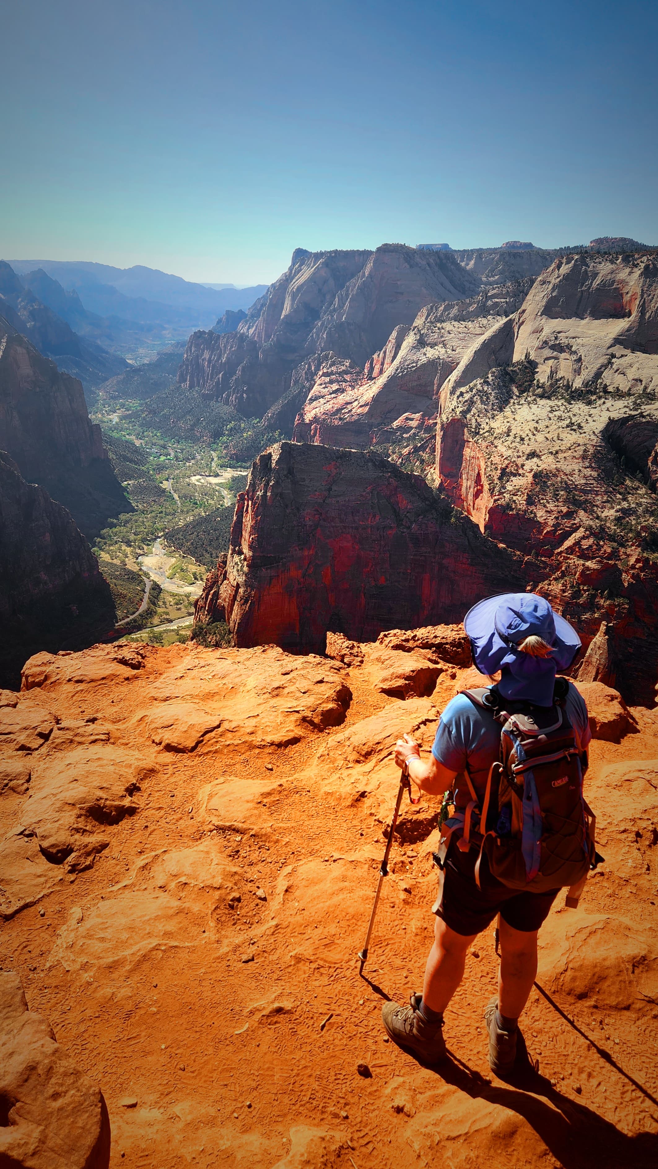 A person hiking a desert canyon with beautiful view in the distance.