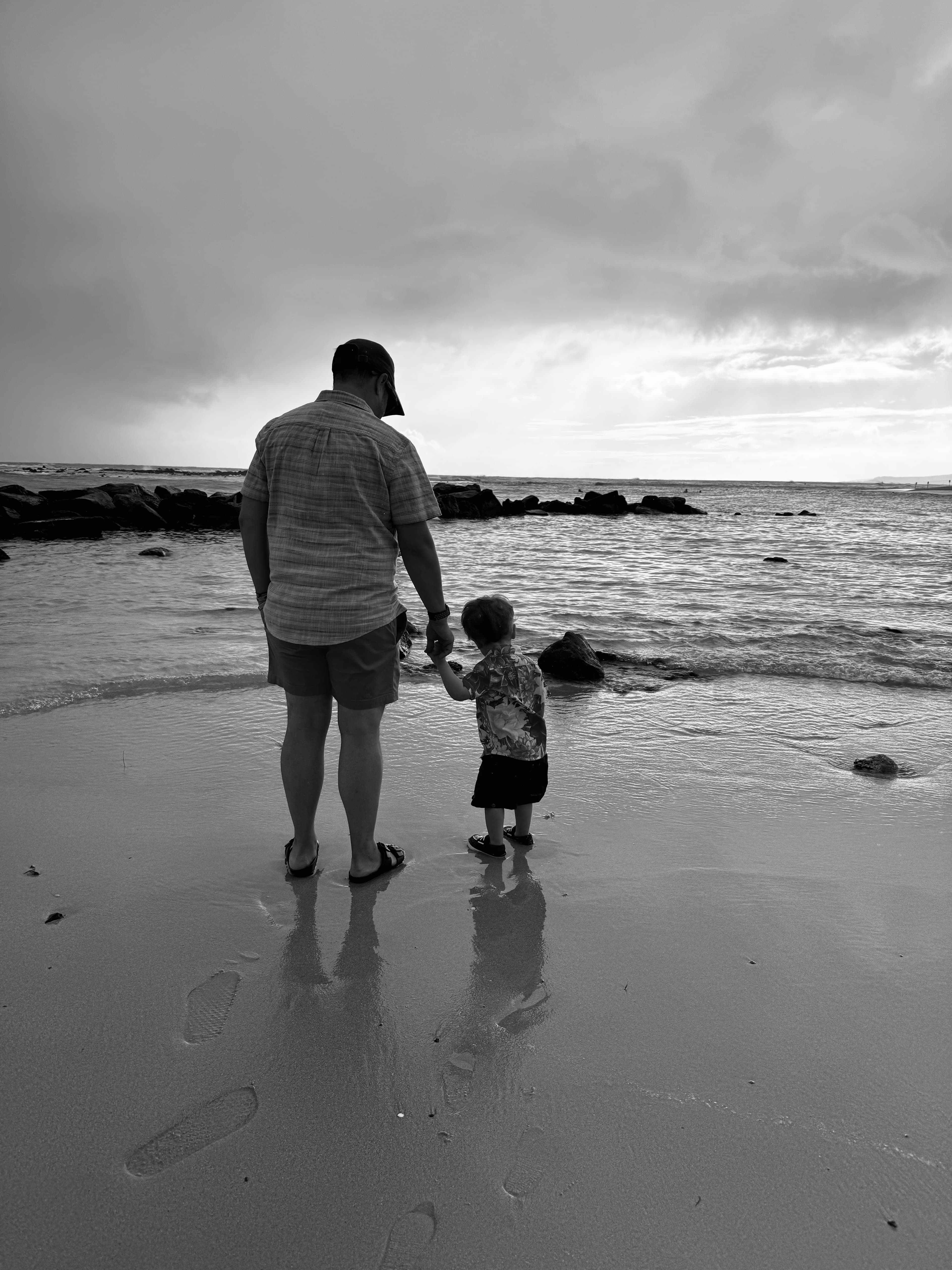Black and white photo of Briana’s family on the beach on a cloudy day