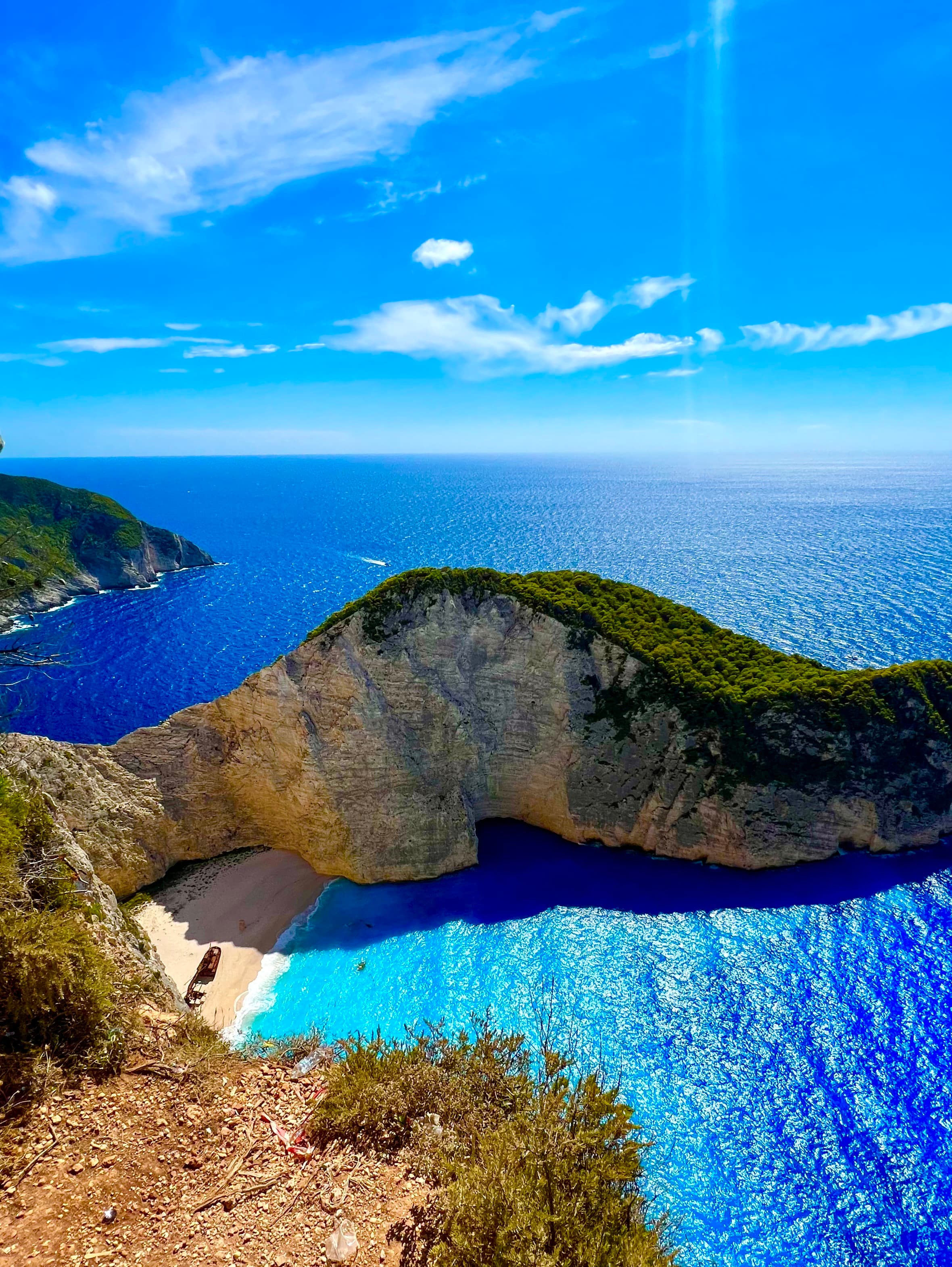 Beautiful aerial view of a small secluded beach and vibrant blue water under sunny skies