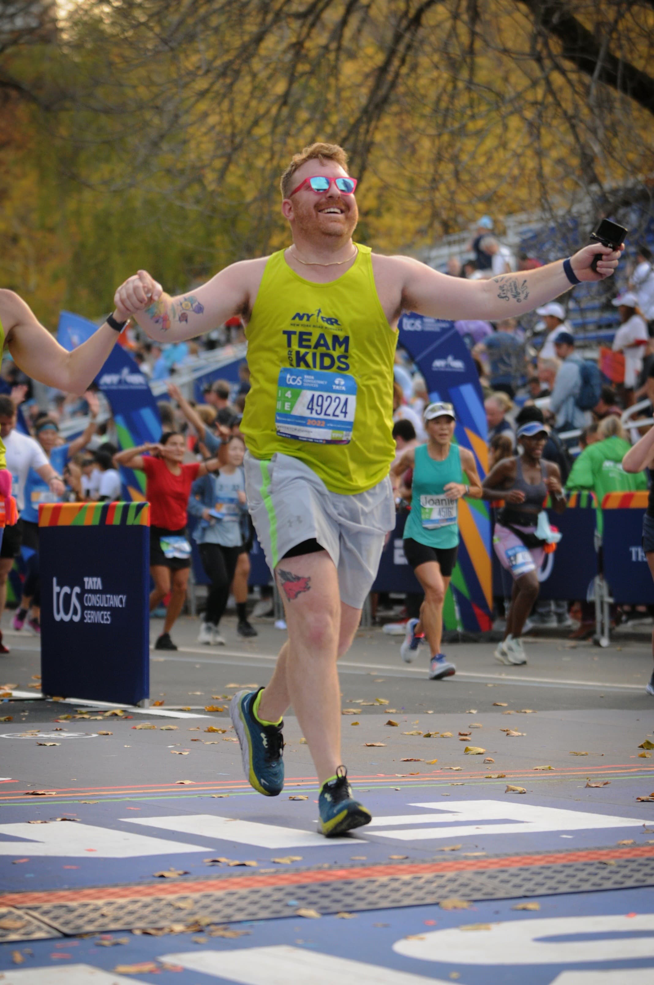 Advisor in a yellow tank top seen crossing the finish line of a marathon