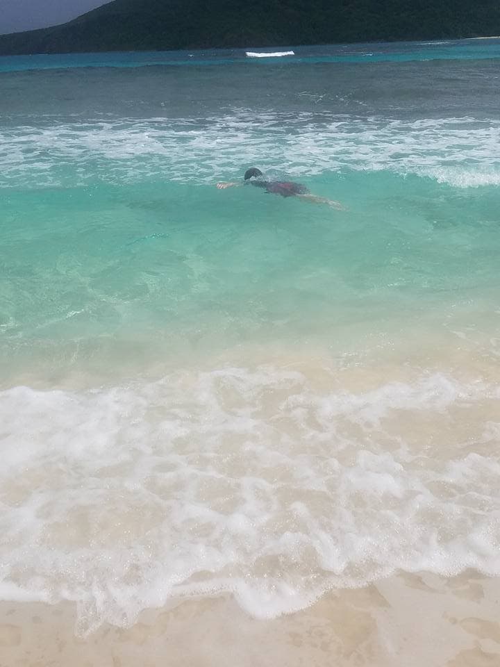 View of waves on shore with a figure swimming underwater