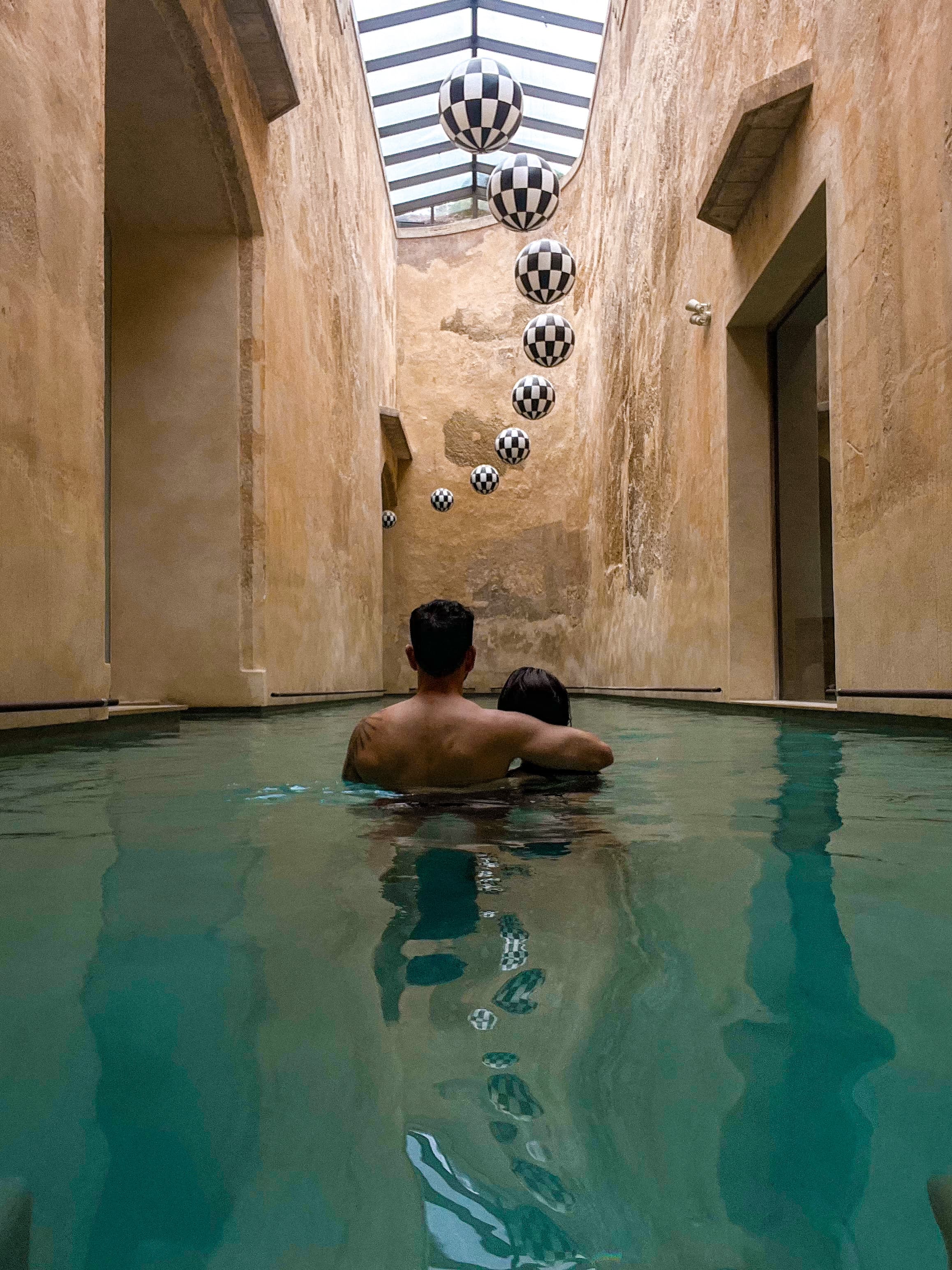 A man and woman swimming in an indoor pool.