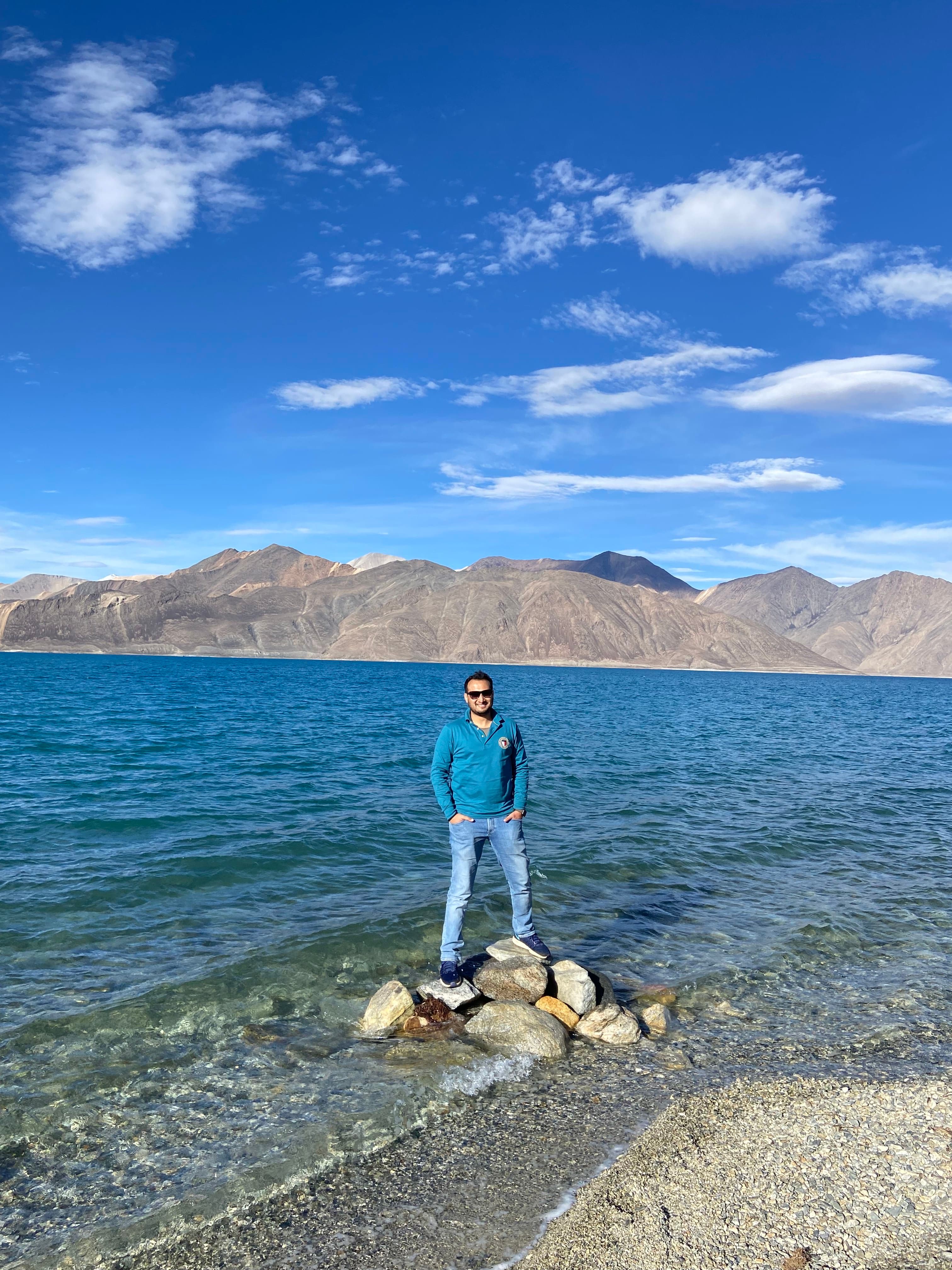 Advisor standing on a small pile of rocks in shallow seawater on a rocky coastline