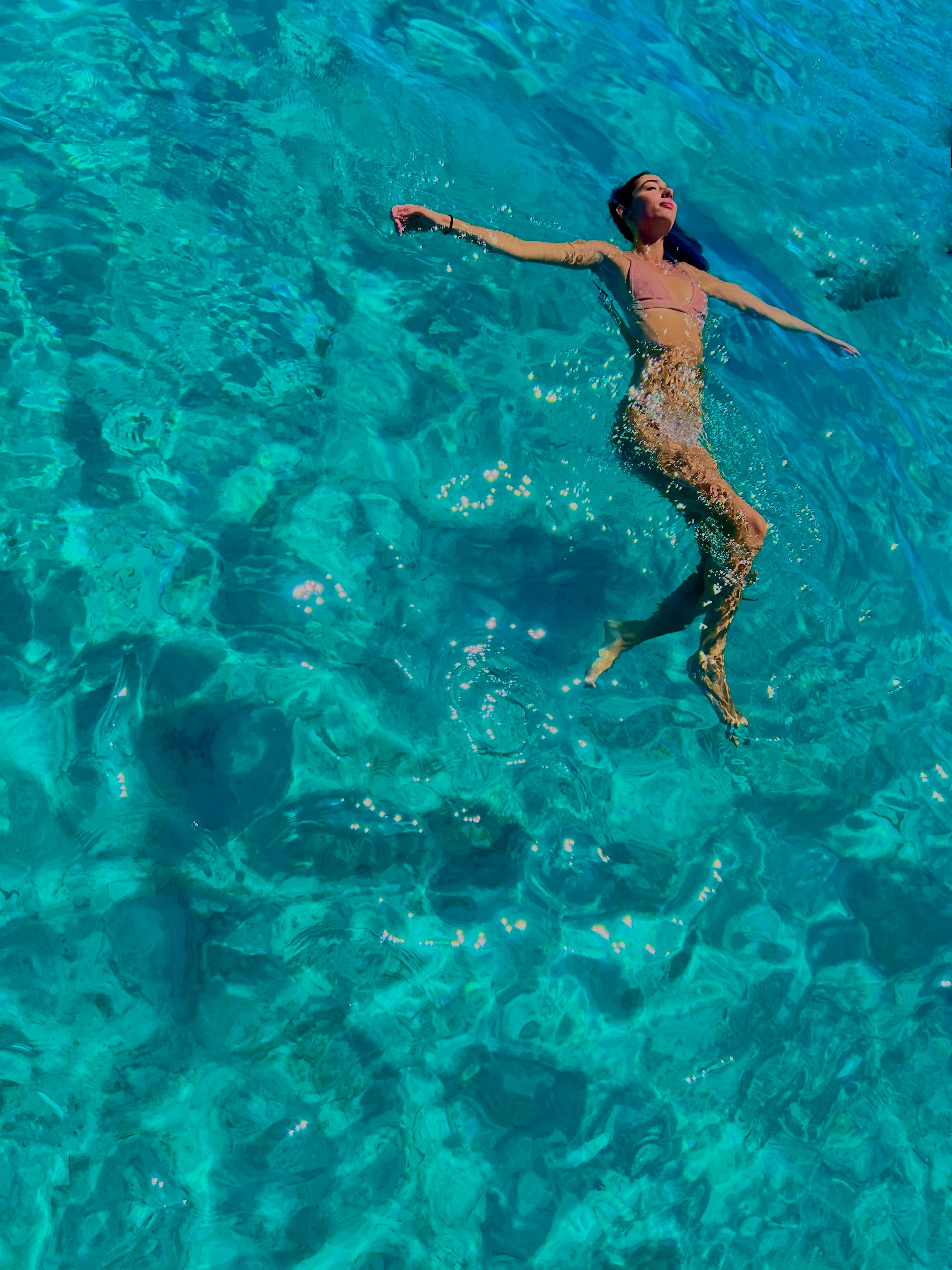 Camille seen from above floating in clear turquoise ocean water