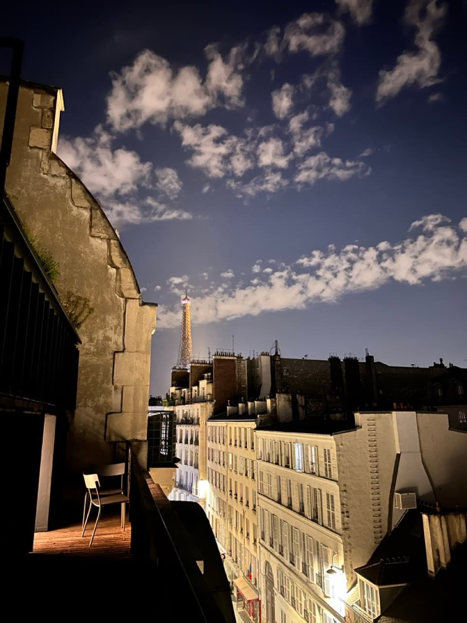 City skyline at night, twinkling lights from rooftop view.