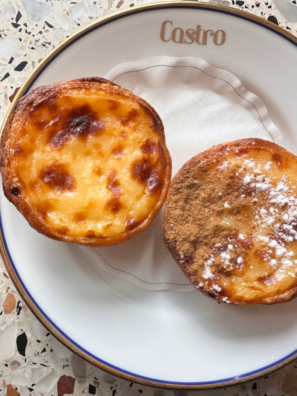 Two pastries on a white plate on a table.