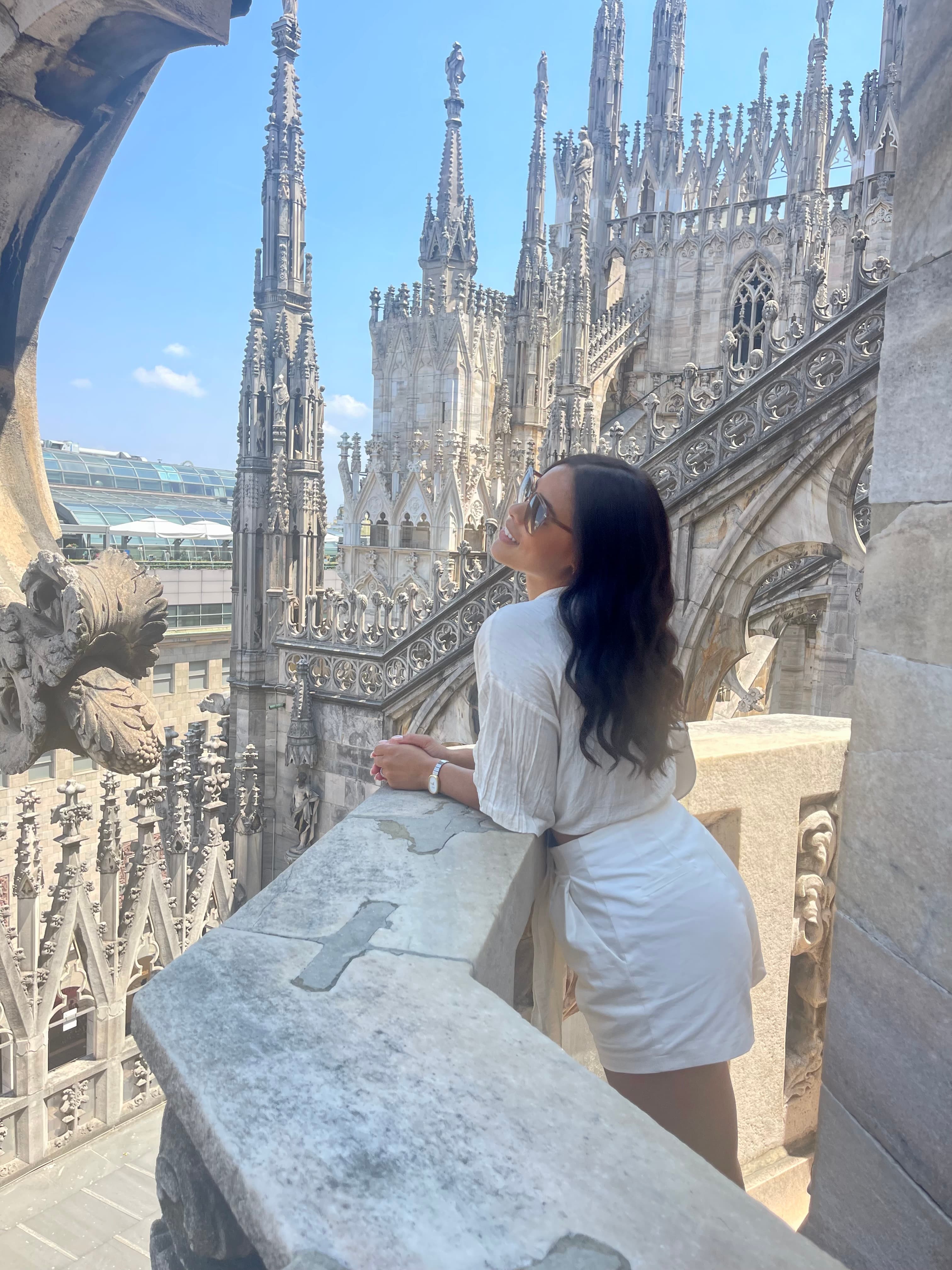 Advisor leaning on a balcony overlooking a large cathedral on a sunny day