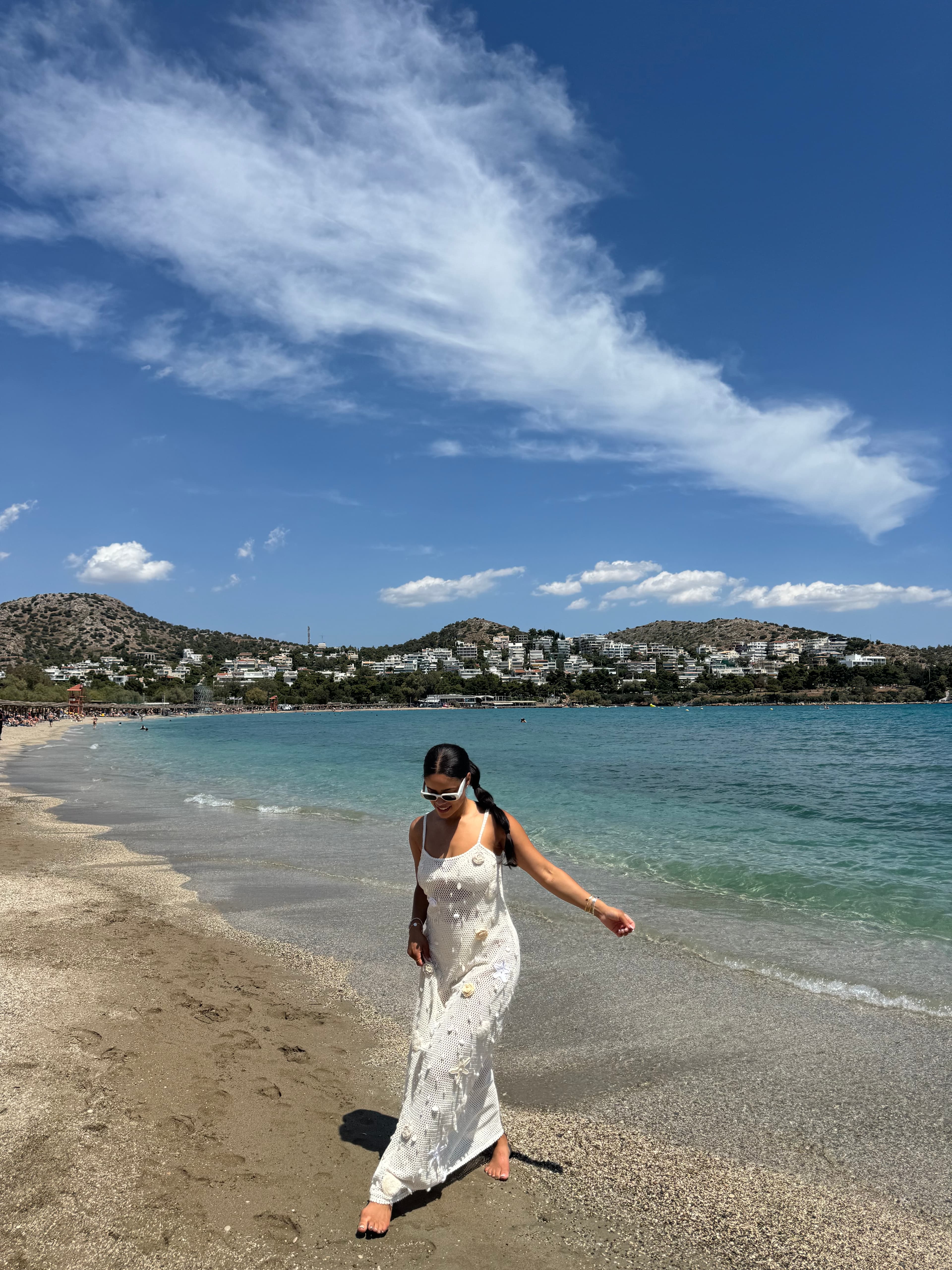 Advisor in a white dress on the beach under sunny skies