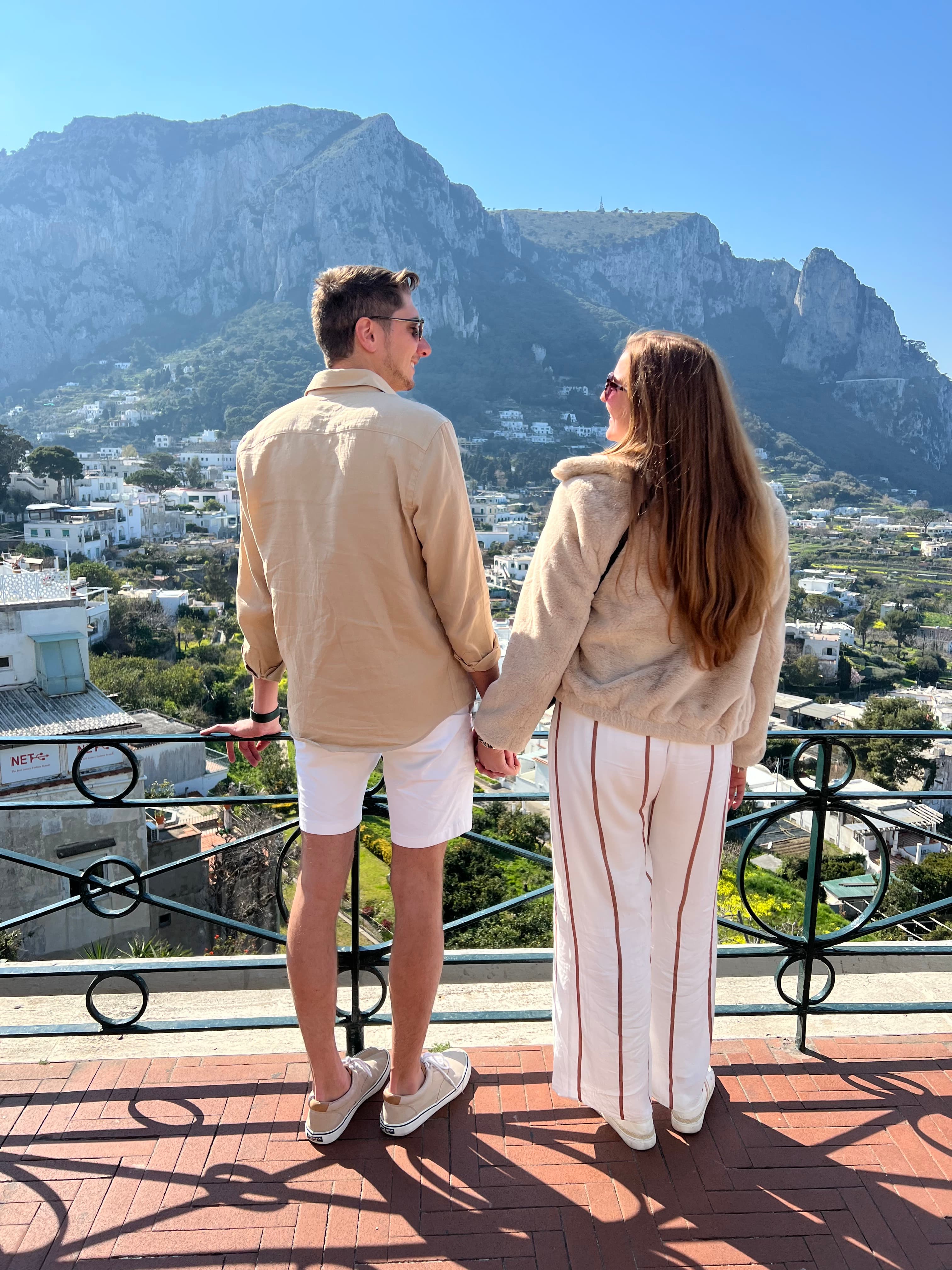 Advisor and her partner holding hands at a viewpoint overlooking a beautiful mountain town on a sunny day