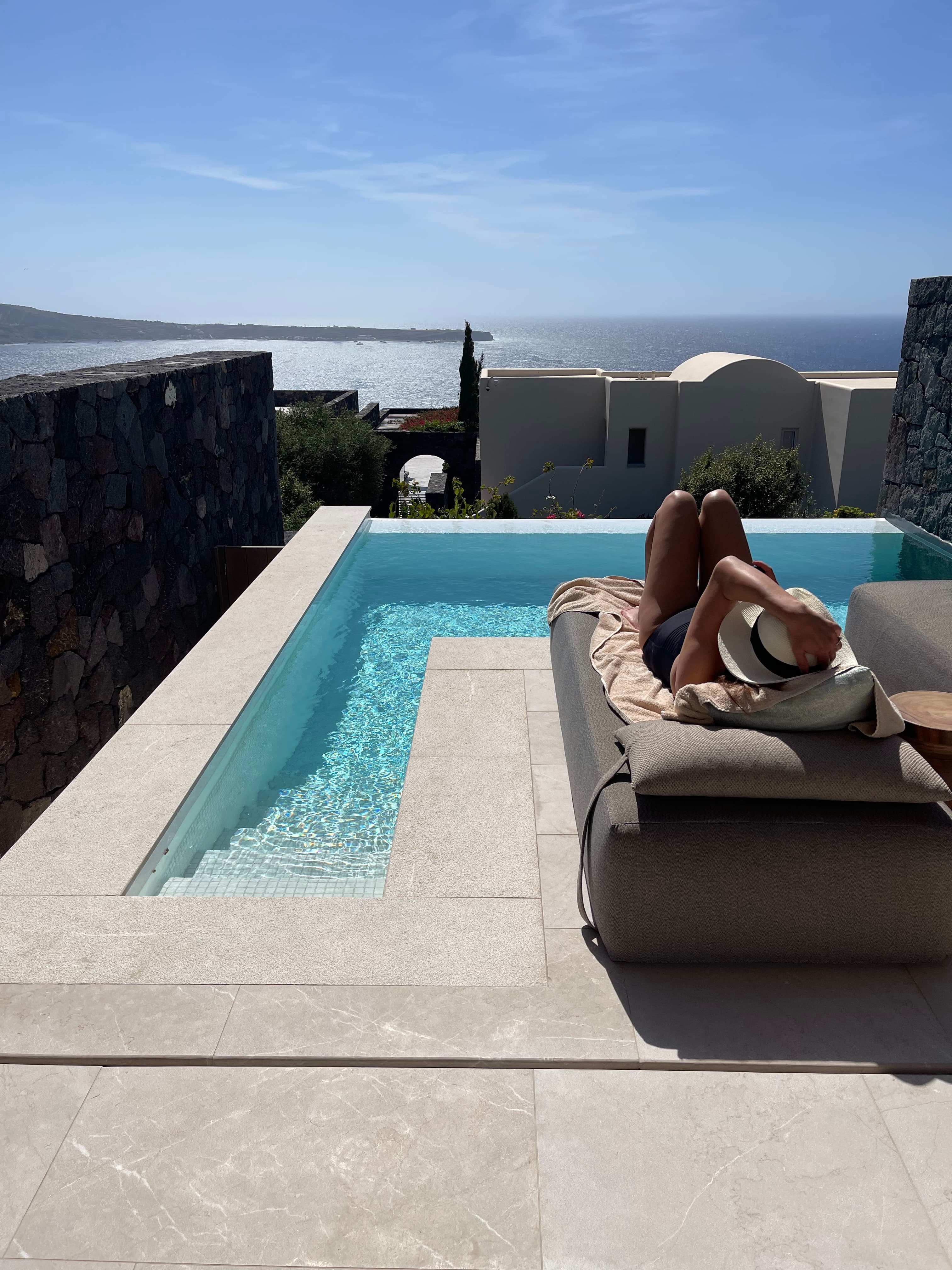 Advisor outside laying by a pool looking towards the ocean in the background.