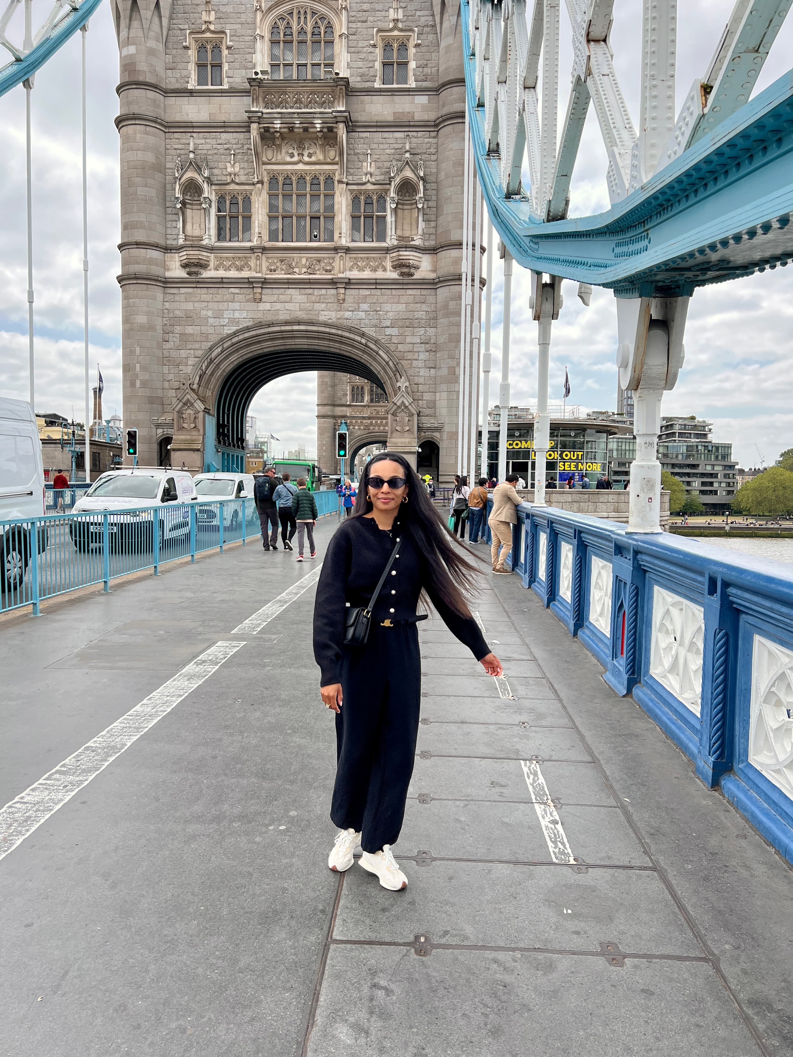 Advisor in all black standing on a bridge on a cloudy day
