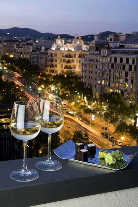 A view of wine and appetizers with a view at nighttime.
