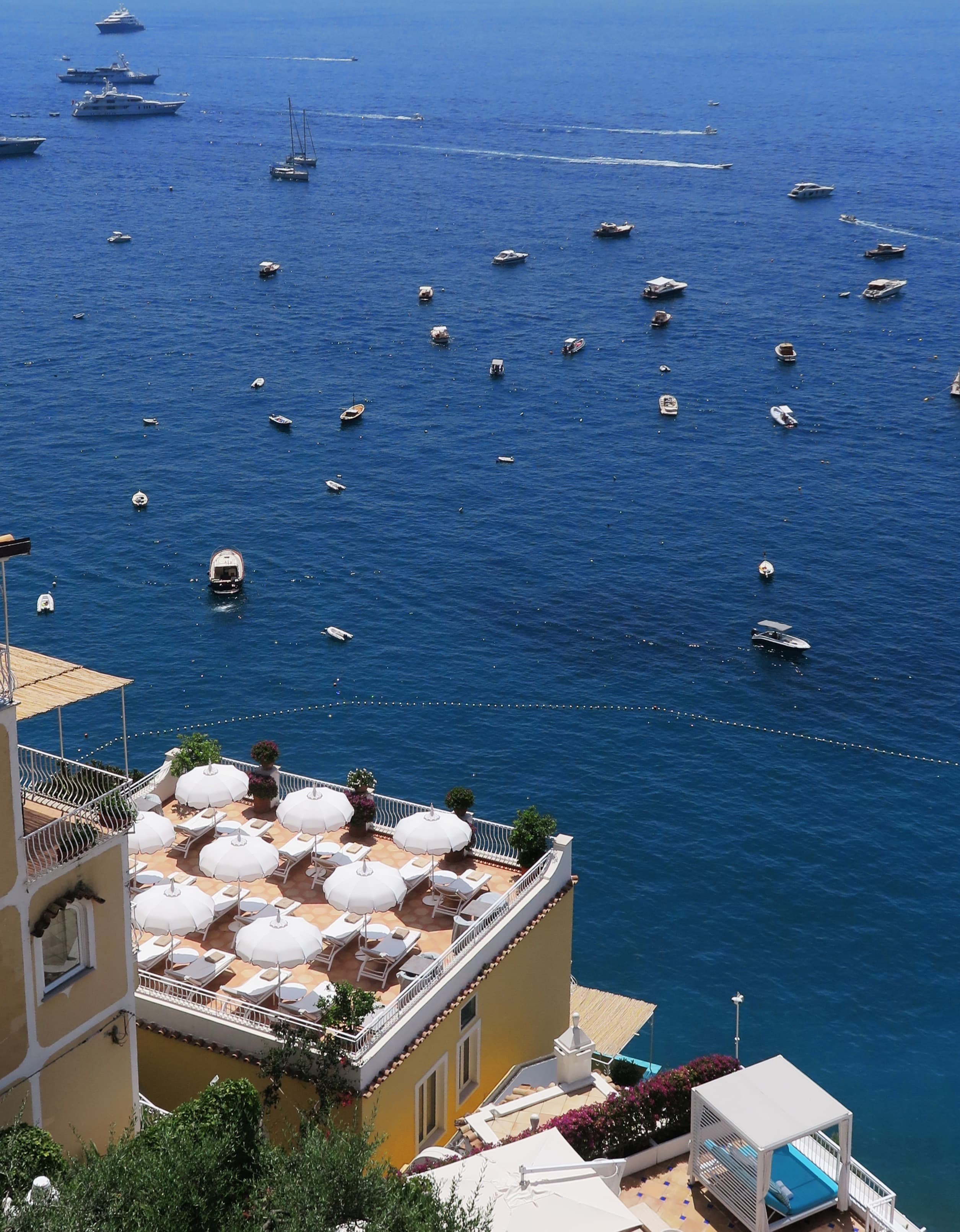 Photo of the side of a building with the ocean and objects in the water.
