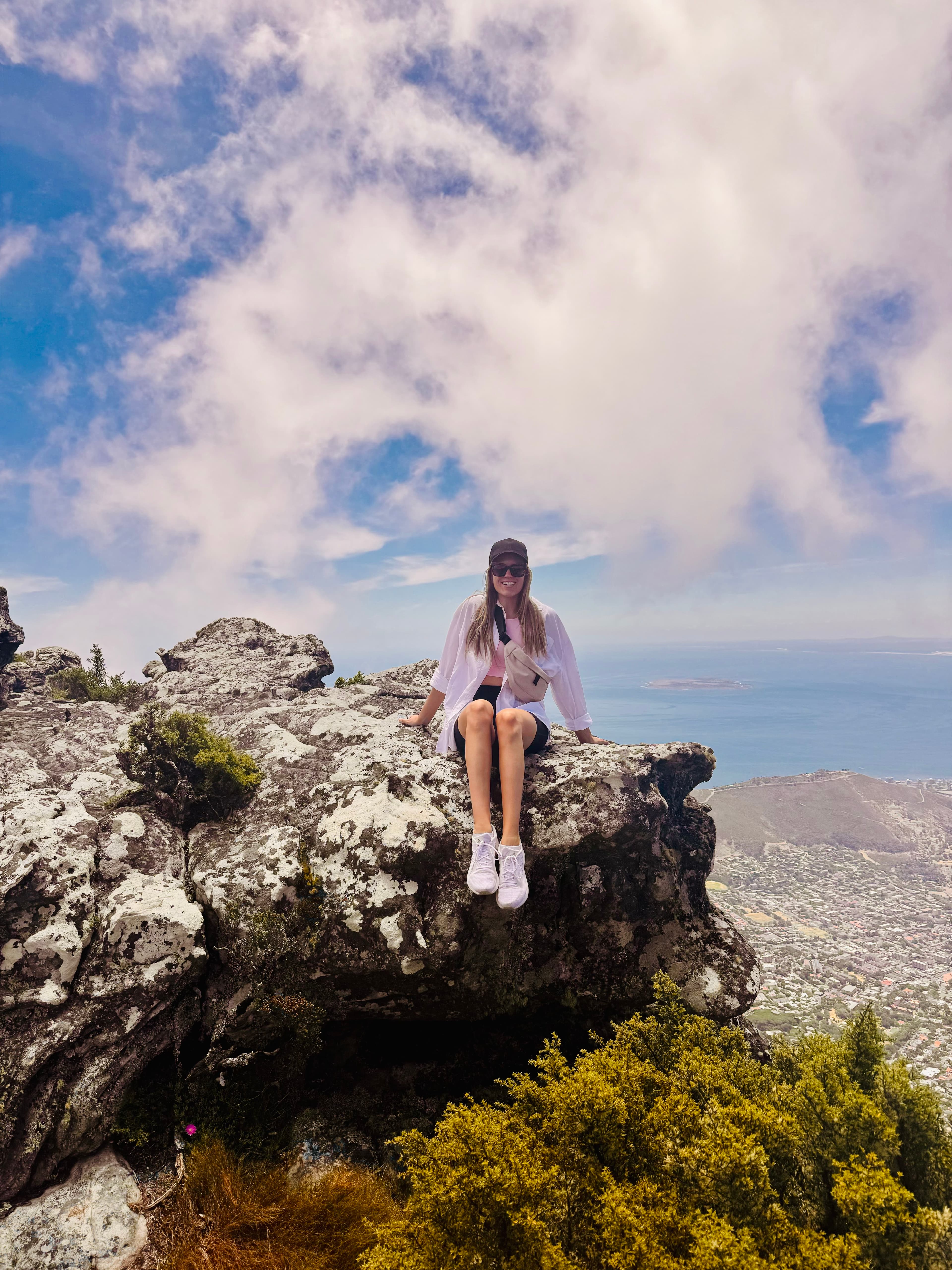 Advisor sitting on the edge of a cliff overlooking the sea on a sunny day