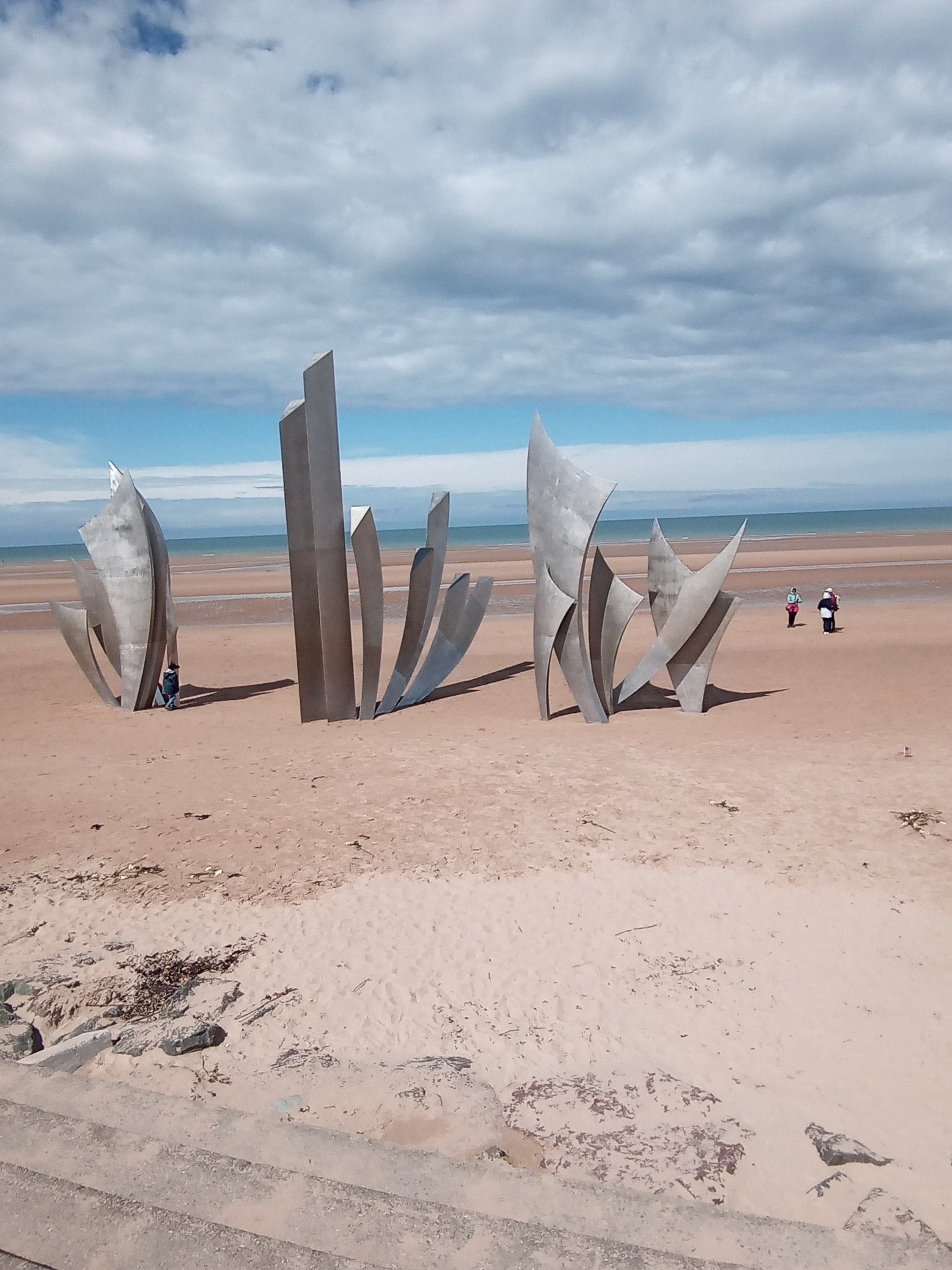 View of abstract metal sculptures on an empty beach during the day